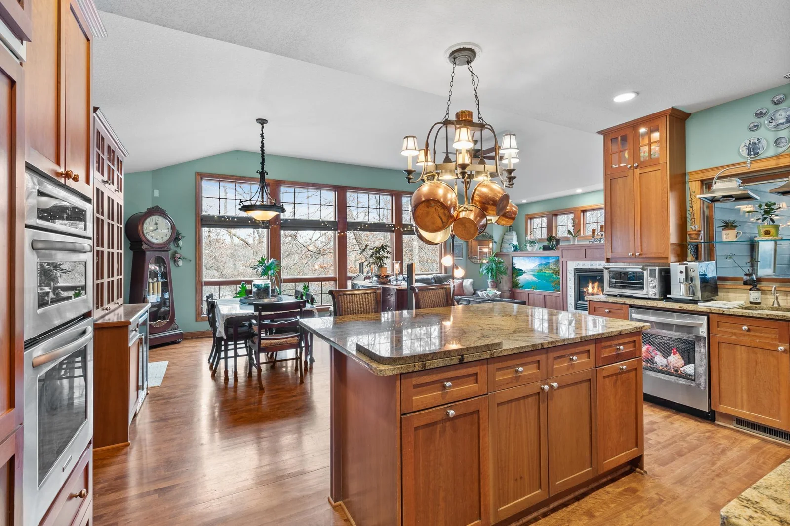 Kitchen viewed from hallway entry. Showing openness to breakfast bar, eating area and family room. Extra high ceilings and floor to ceiling windows overlooking the backyard and koi pond.