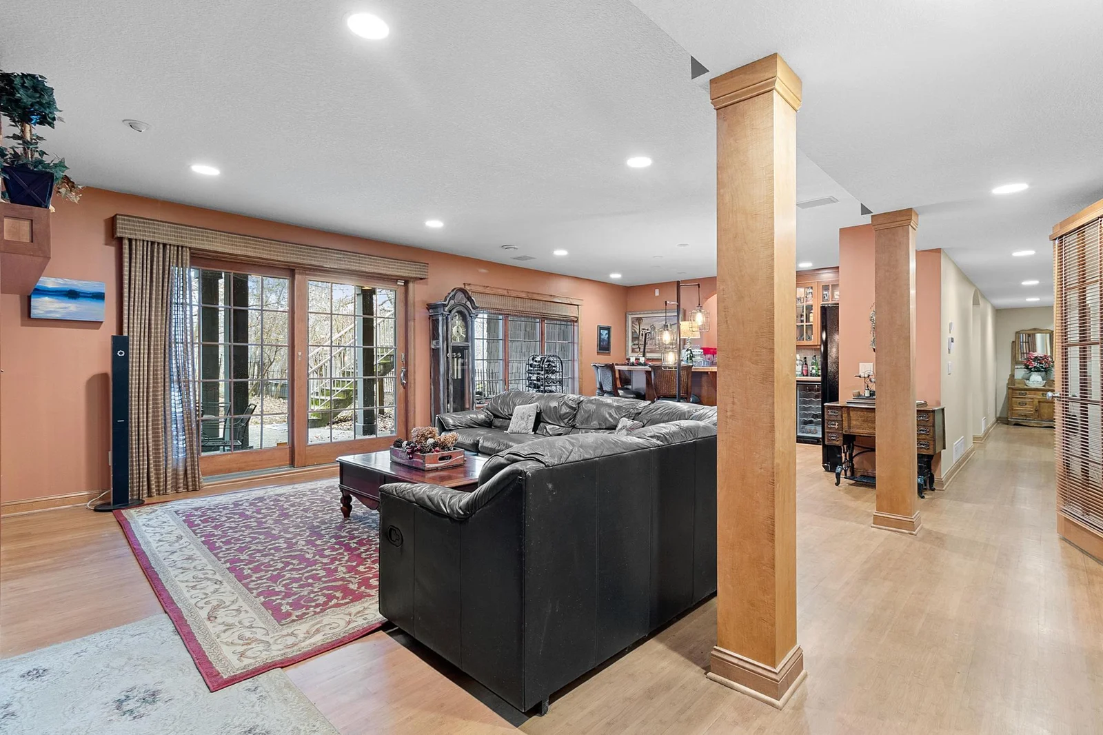 Lower-level recreation room. Walk-out slider to hot tub, rod iron fenced area and stairway to upper deck. View of wet bar and hallway to lower-level bedrooms.
