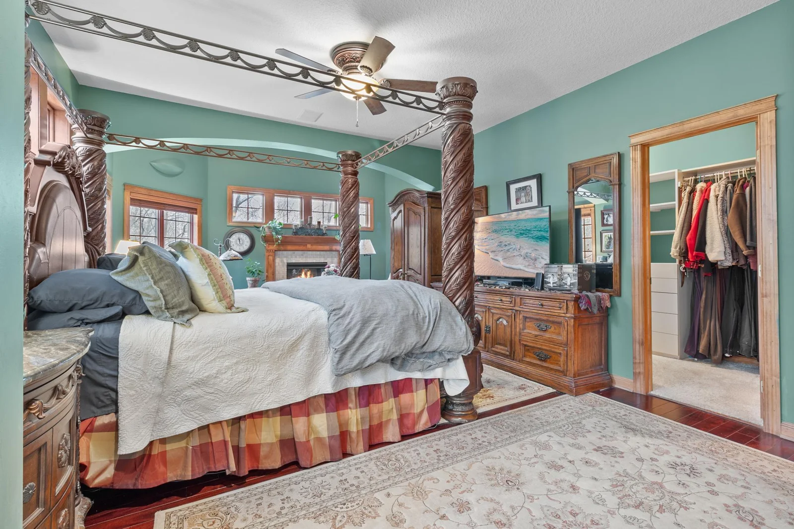 Primary bedroom suite with view toward  sitting area with fireplace and door to full length covered deck. Entry to first walk-in closet shown. Wired LAN available