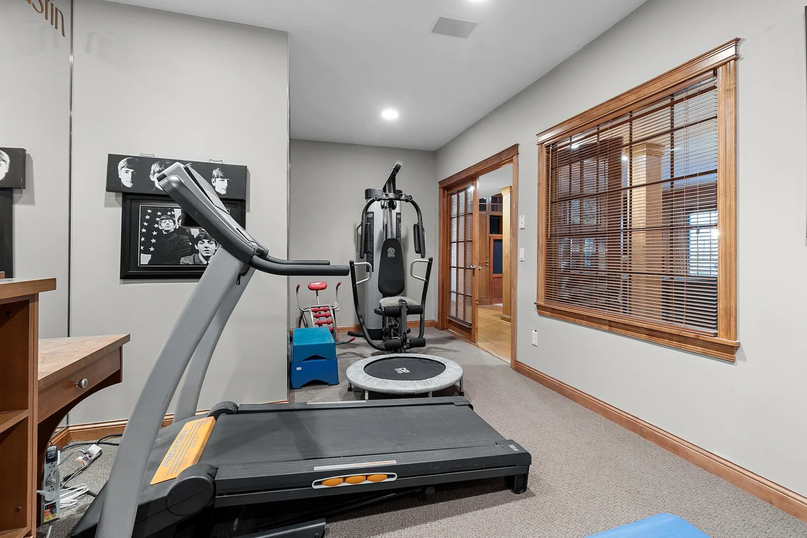 Lower-level exercise room with space for several machines and weights. Mirrored walls and French, windowed doors to lower-level hallway.