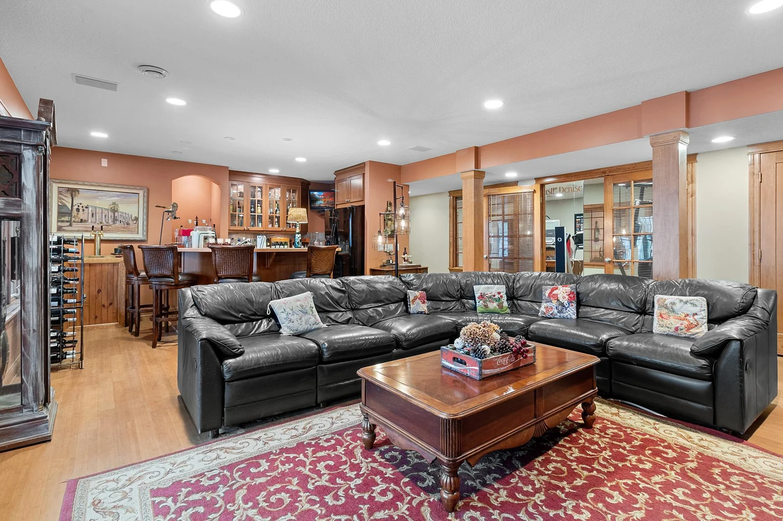 Lower-level recreation room viewed looking toward wet bar and exercise room.