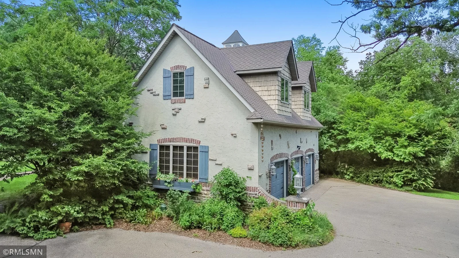 Side view of attached 3-car heated garage with spacious office / bonus room above.