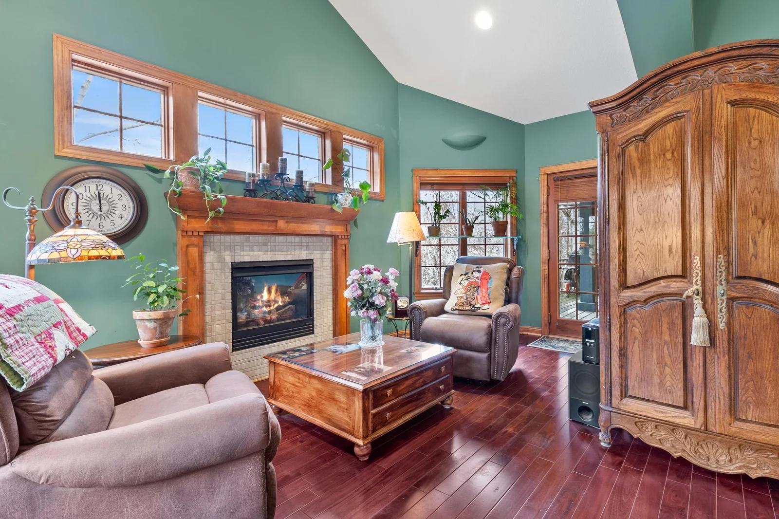 Primary bedroom suite with fireplace, mahogany hardwood floors, extra high ceilings, view to back yard and woods. Door to full length covered deck.