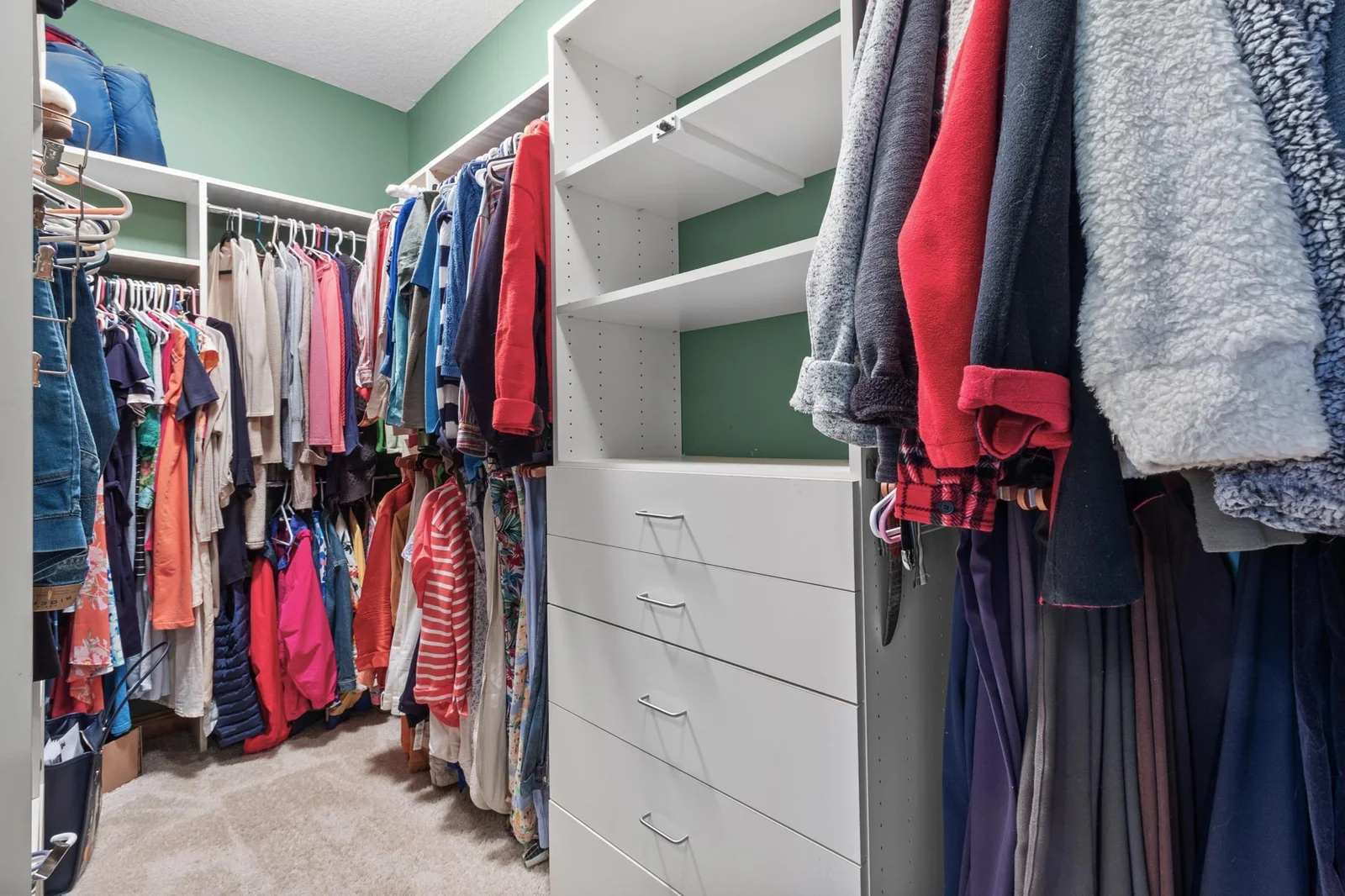 Primary bedroom first walk-in closet with built-in storage.