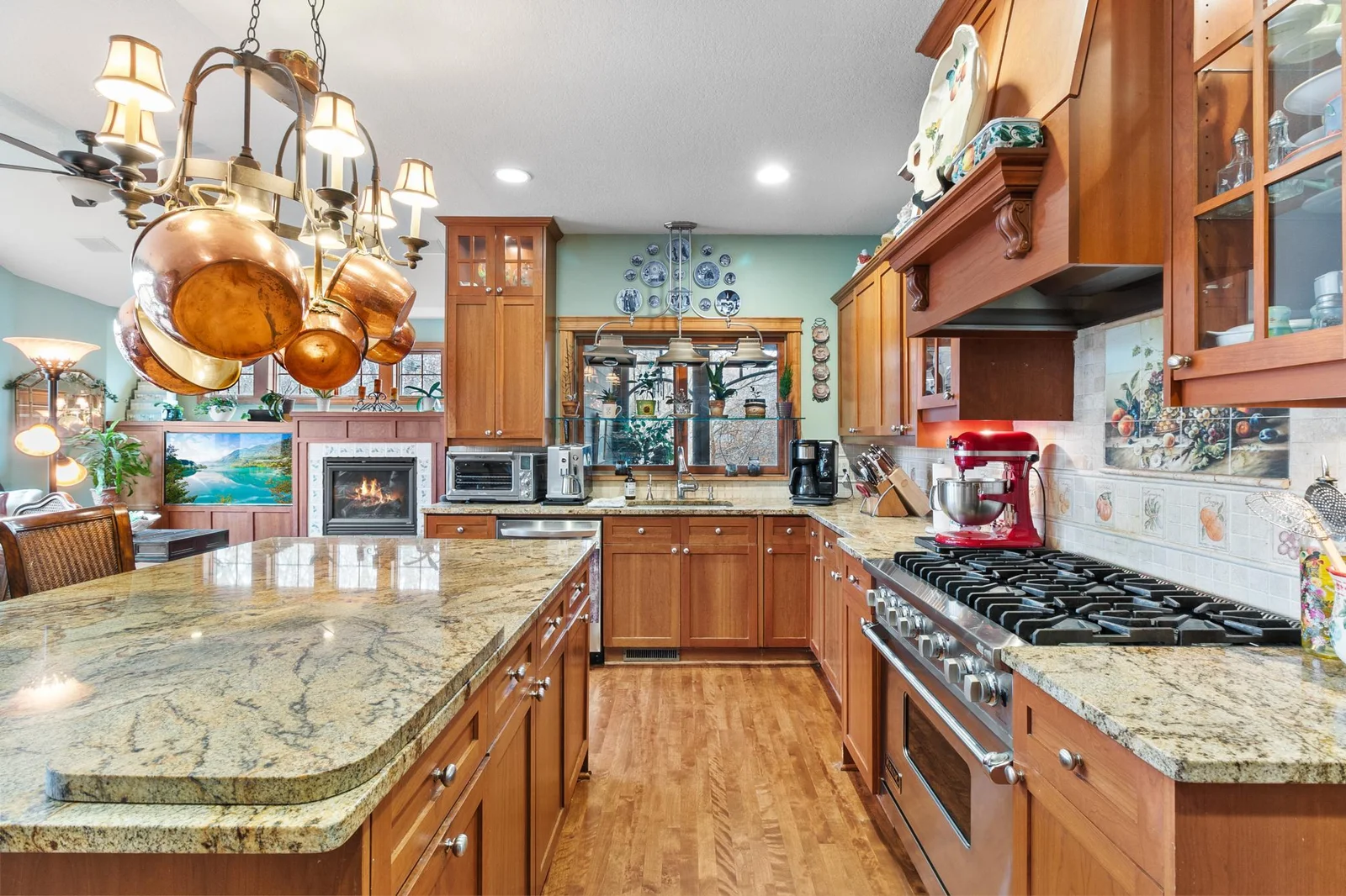 Kitchen showing breakfast bar / food prep area, Viking natural gas stove, cherry cabinets and pass through to screen porch. Sink includes instant hot water and garbage disposal.