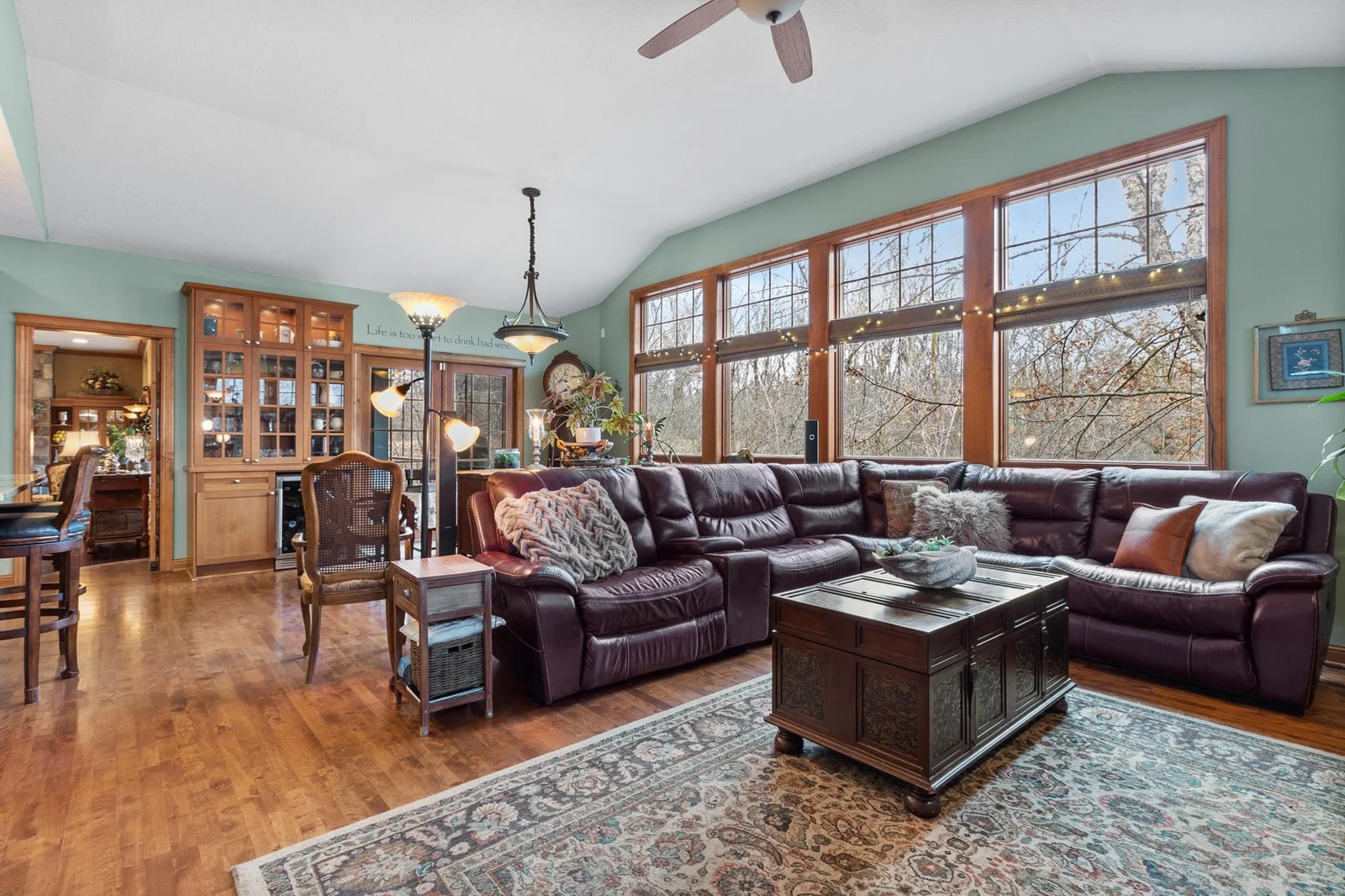 Family room showing view to breakfast area and floor-to-ceiling windows overlooking the back yard.