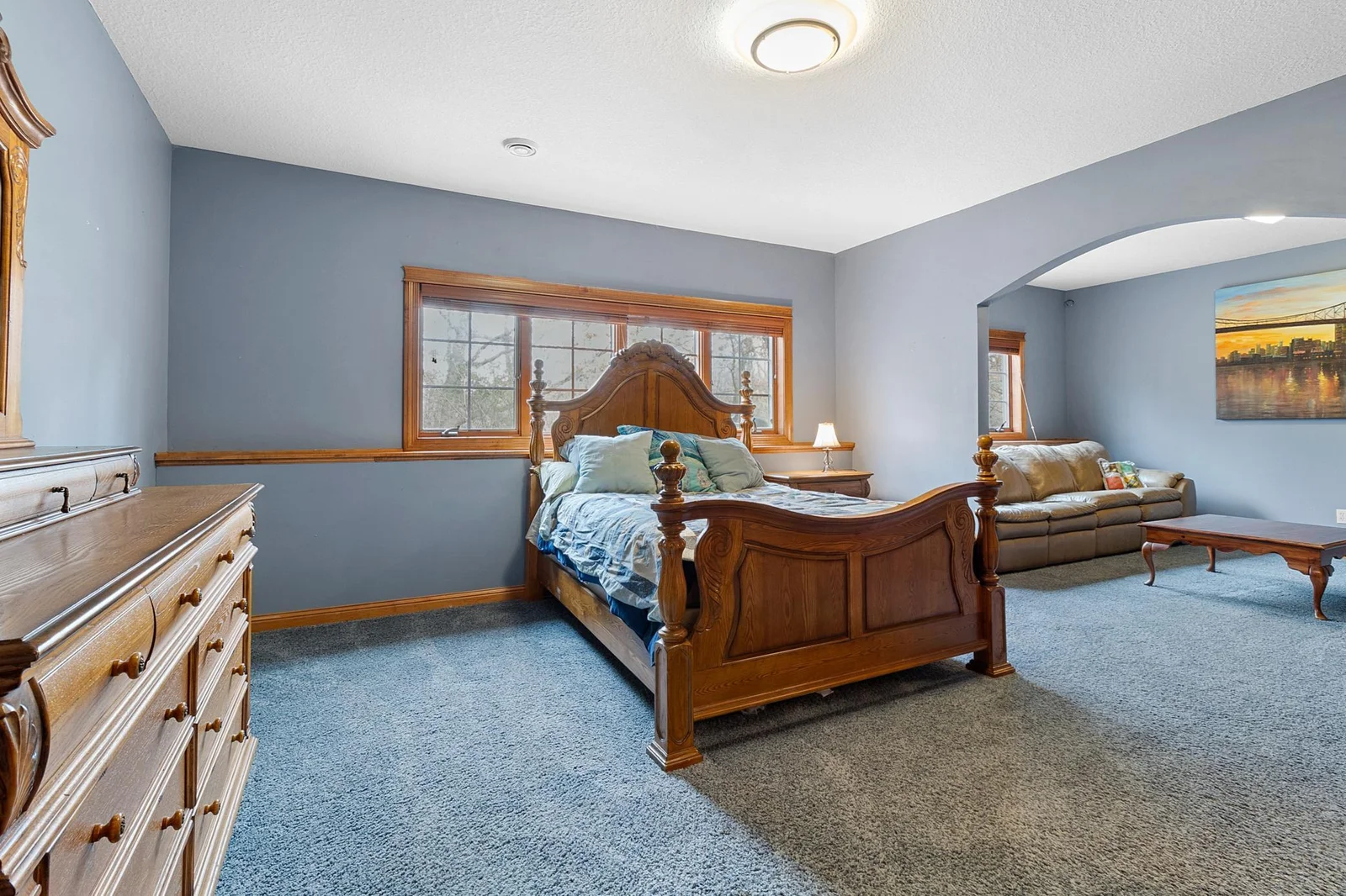 Lower-level first bedroom suite open to separate sitting area and full en-suite bathroom and walk-in closet. View toward backyard and koi pond.