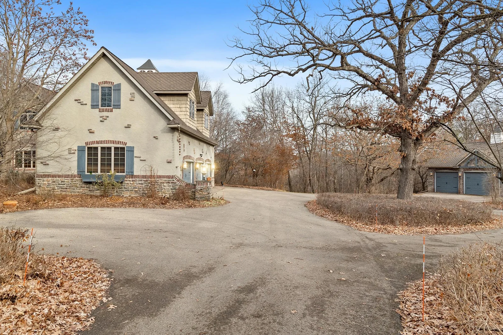 Approach from driveway to attached three car garage and three more stalls in the detached garage.