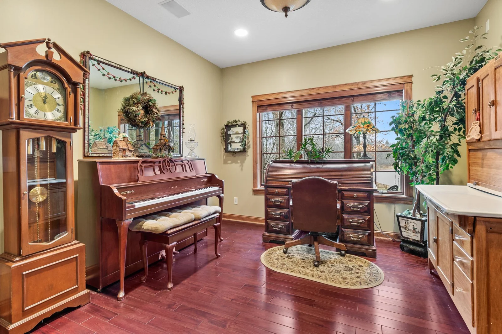Office with mahogany hardwood floors. Viewed from main hallway with windows to the front yard and acre size pond. Ceiling speakers connected to whole house audio.
