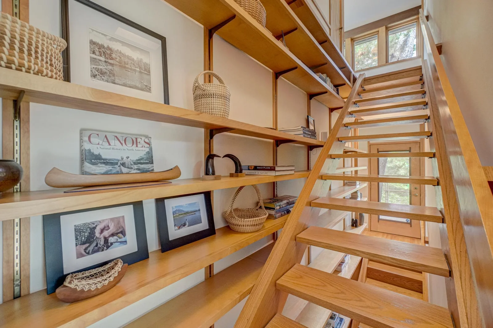 Speaking of stairways, the home's design features a continuous staircase system flanked by shelving on one side, brilliantly integrating the three floors of the home.