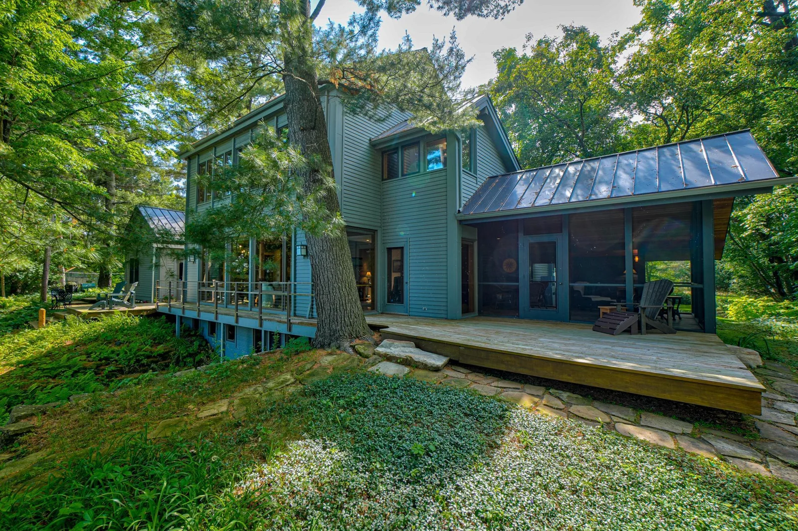 The extensive deck runs the length of the home, tying together the exterior from the screen porch to the garage.