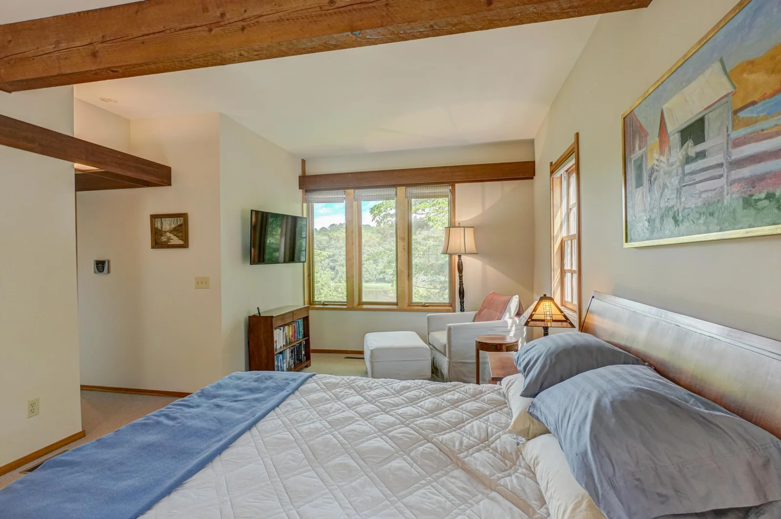 The exposed beam adds a rustic element to the spacious primary bedroom.