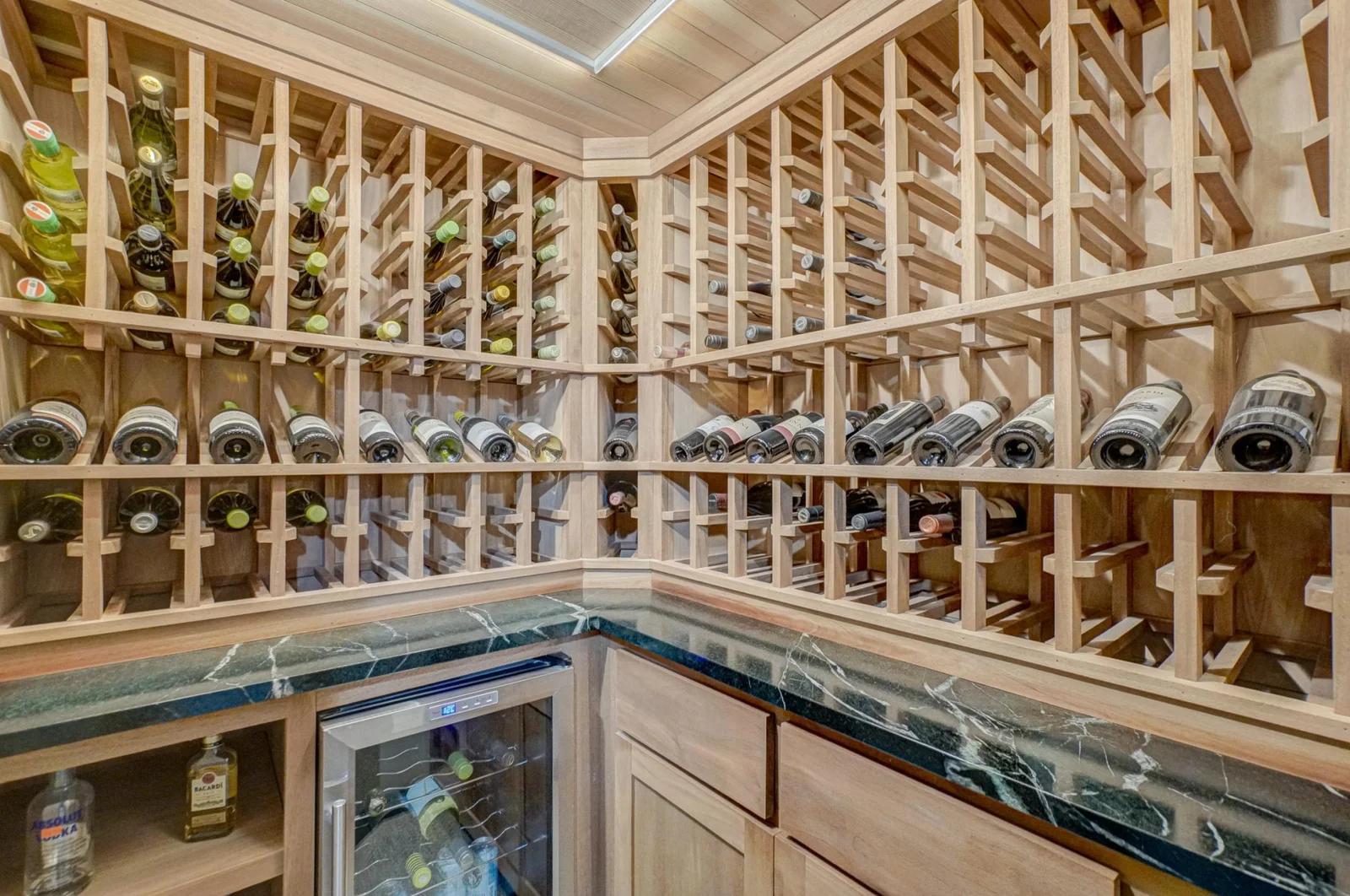 One of the fun features in the lower level is this custom wine pantry added in 2019. It has maple shelving, a soapstone counter, custom cabinets, and a beverage refrigerator.