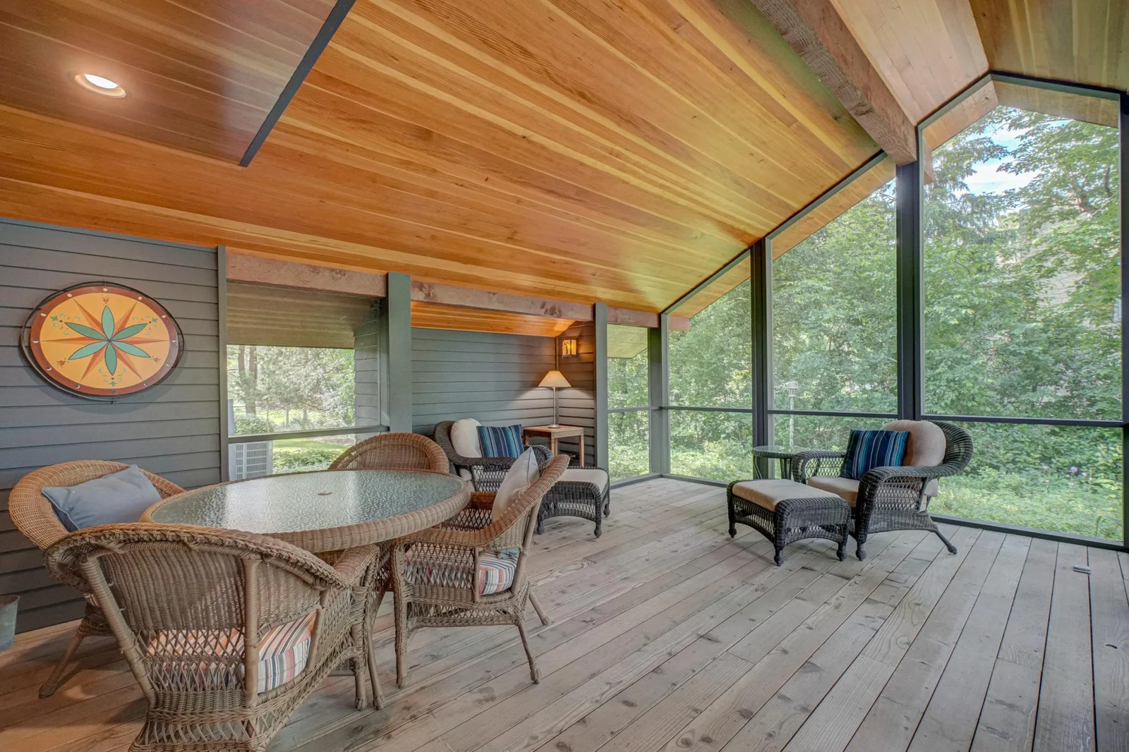 This screen porch designed by renowned architect Kelly Davis becomes the summer living and dining room. In 2017, Hagstrom Builder installed the Douglas fir ceiling.