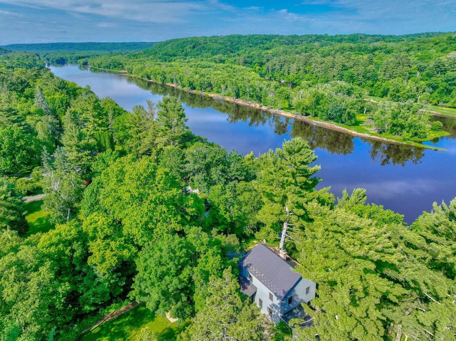 Tucked in a private wooded setting, the home still enjoys open river views from nearly every room.