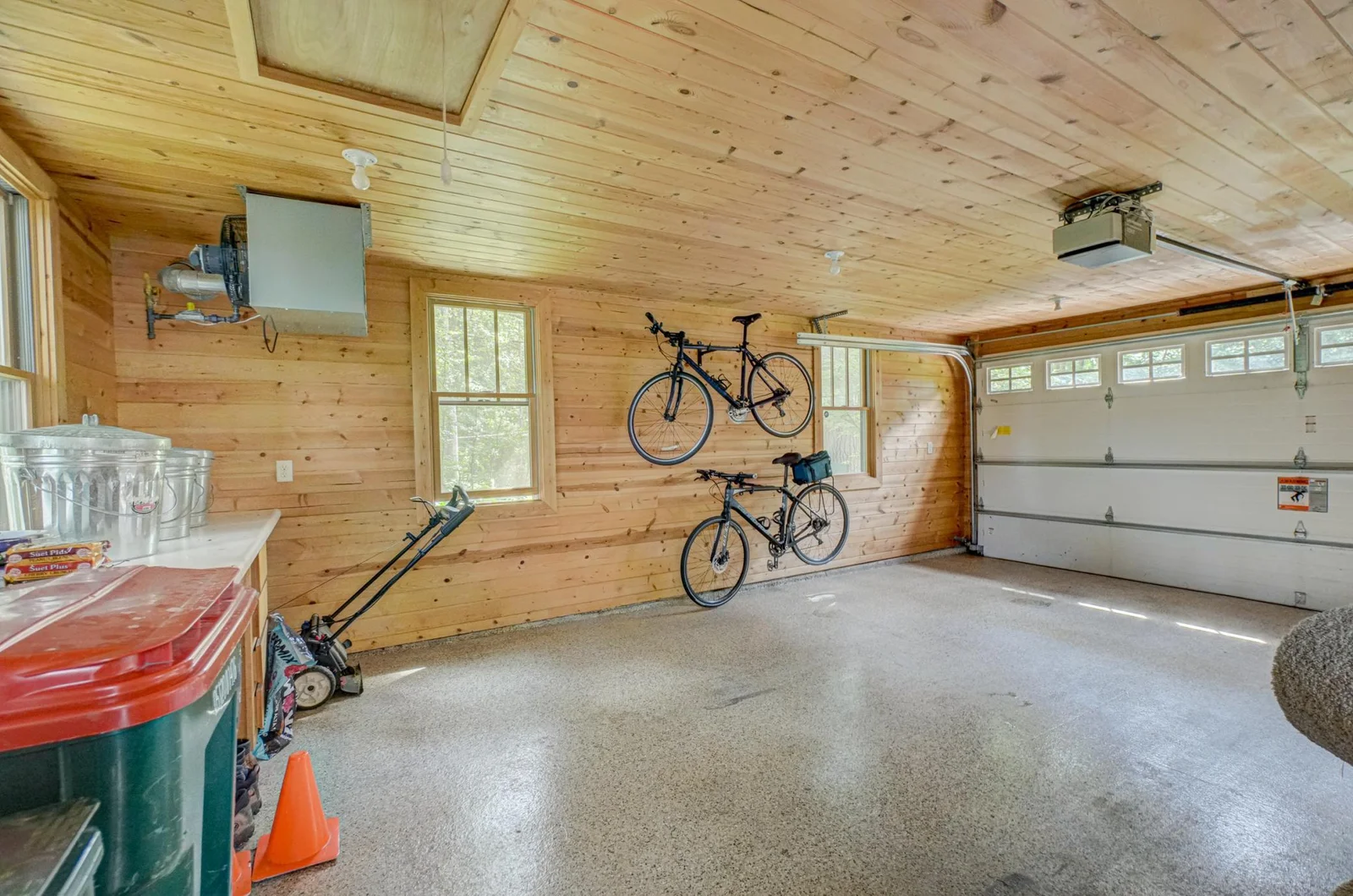 A new concrete pad, insulated floor, and new windows were installed. The epoxy floor protects the new concrete. The walls were insulated and paneled in pine.
