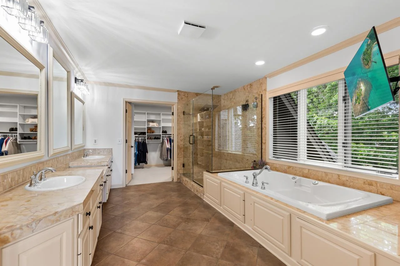 Spa-like ensuite with soaking tub, separate shower, and double vanity.