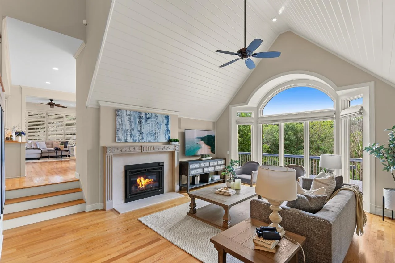 Dramatic Great Room with fireplace, floor-to-ceiling windows, and walkout to deck.