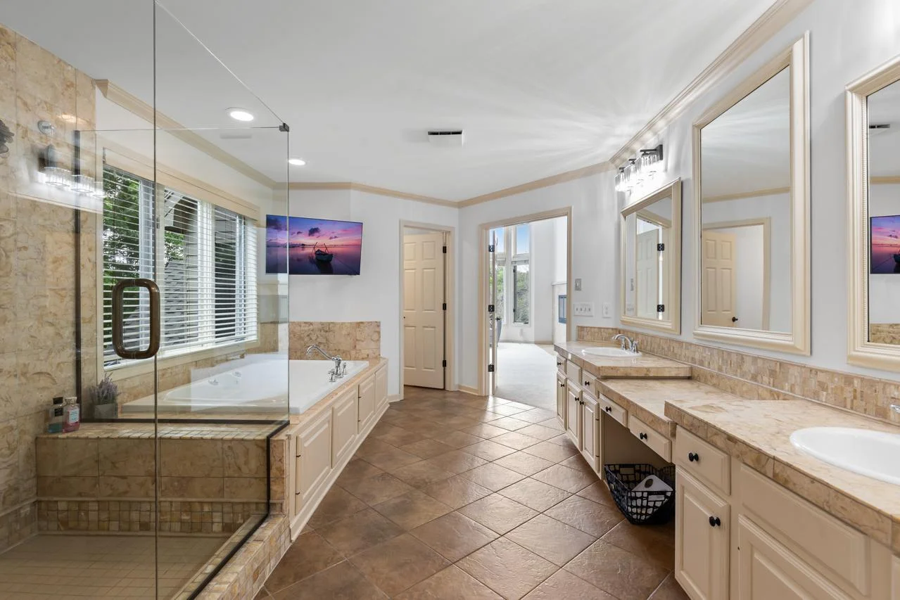 Spa-like ensuite with soaking tub, separate shower, and double vanity.