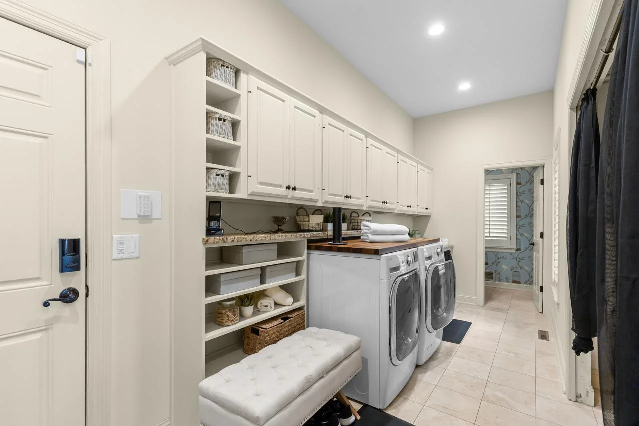 The laundry room is designed with convenience in mind, offering abundant cabinetry and storage solutions to keep everything organized and within reach.