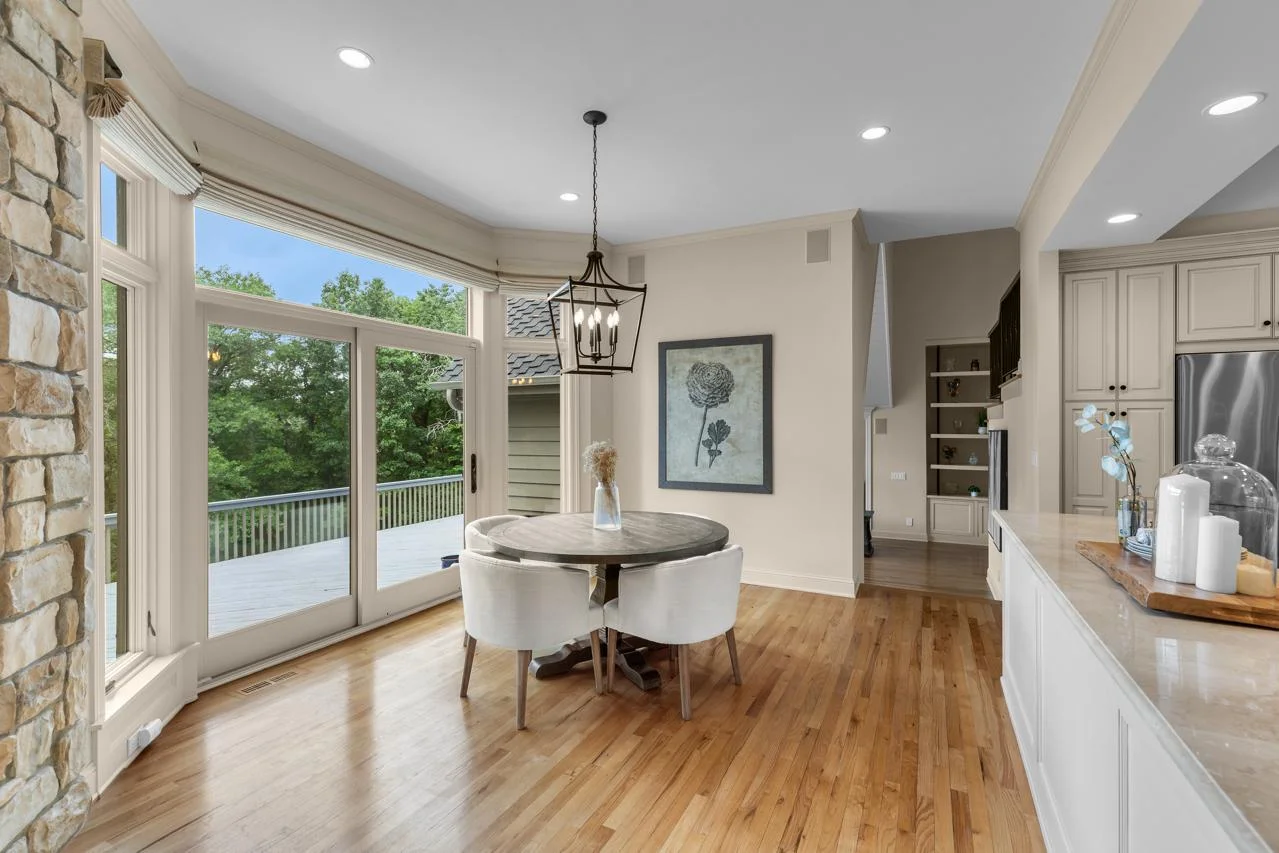 Informal dining area with backyard views and access to deck. Natural light floods the space.
