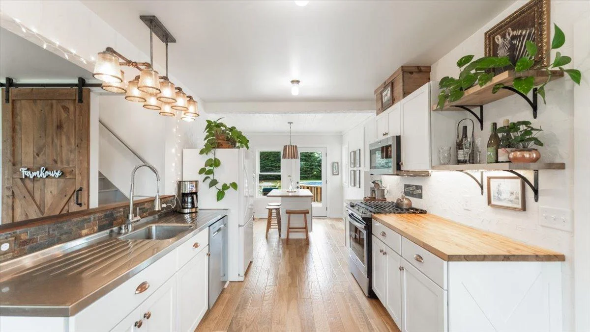 Kitchen features wood floors, butcher block countertops, and an island.