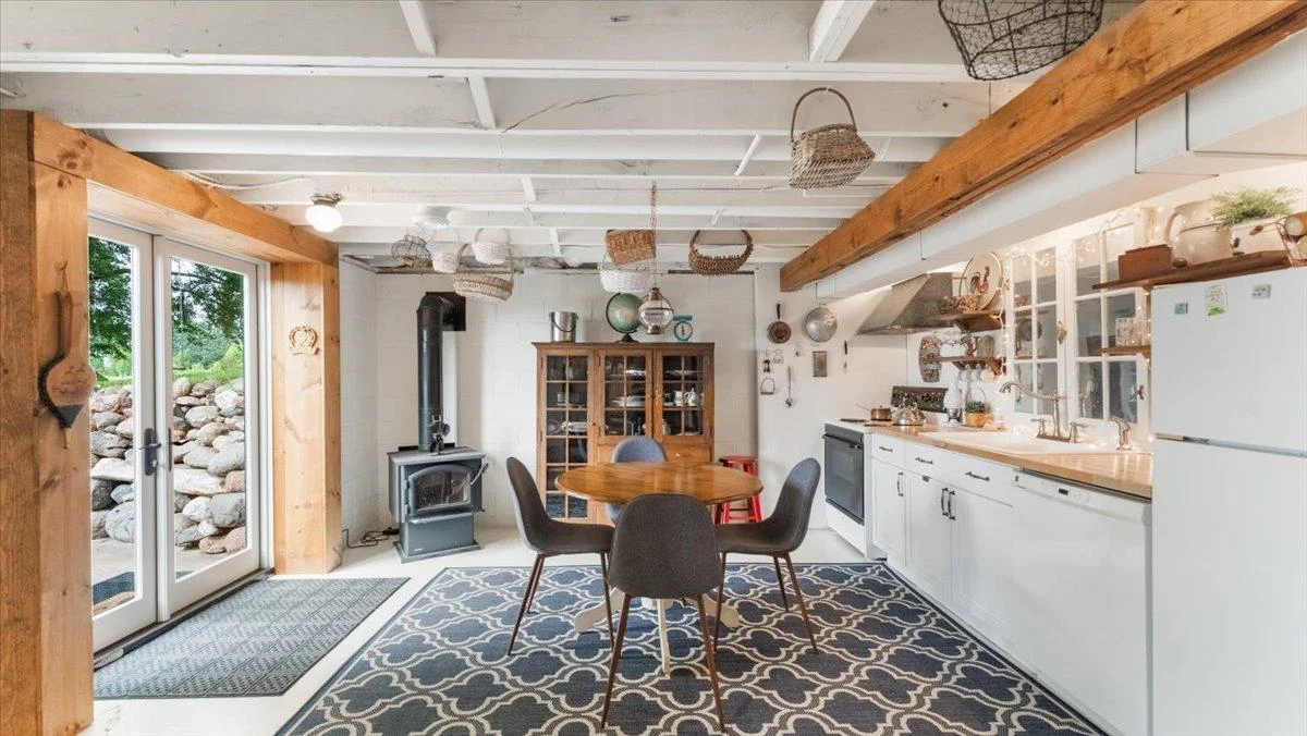 Lower level features a wood burning stove, a kitchenette, and a patio door that walks outside to a beautiful patio.