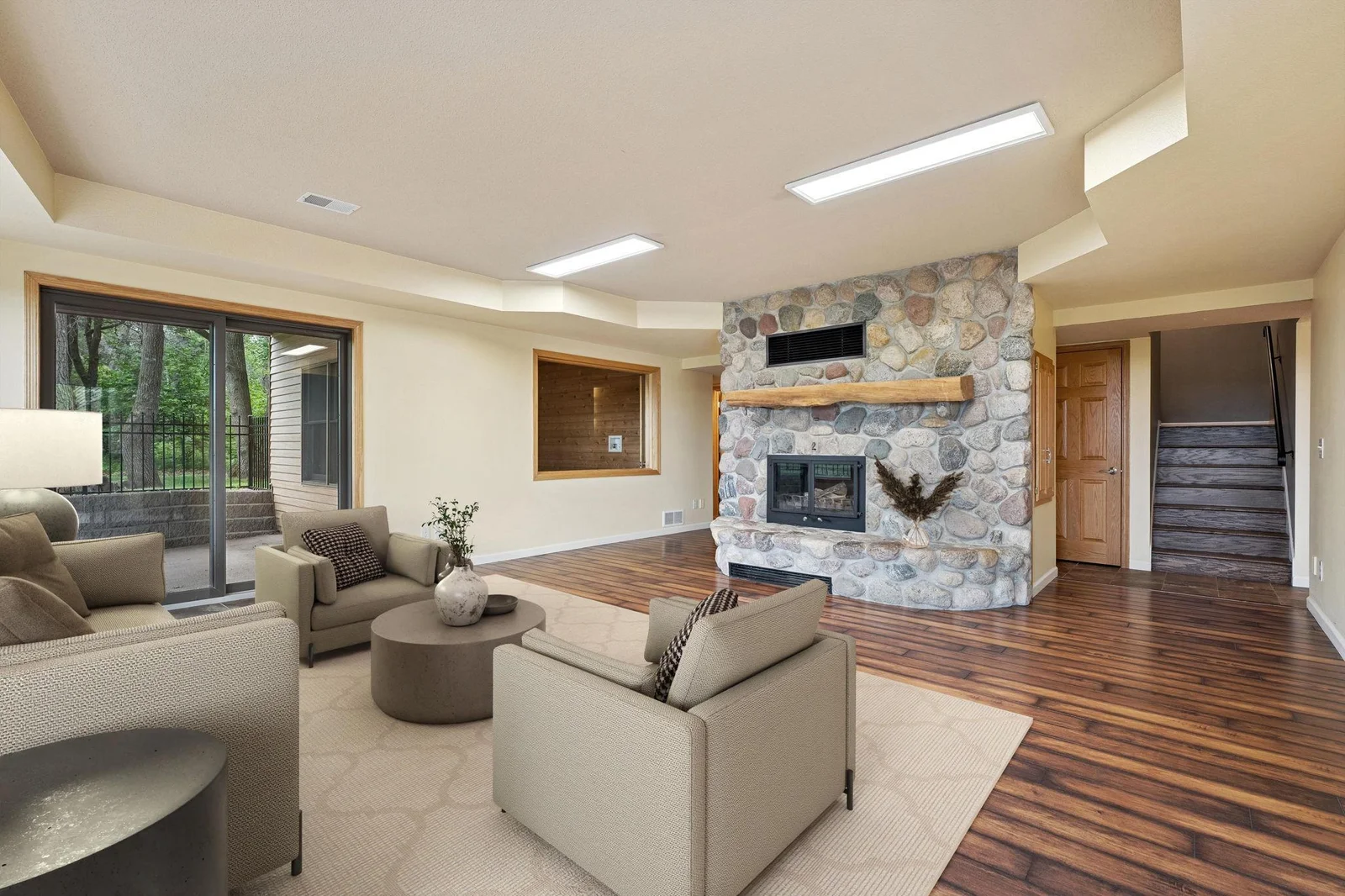 Family room with wood burning stone fireplace (virtually staged)