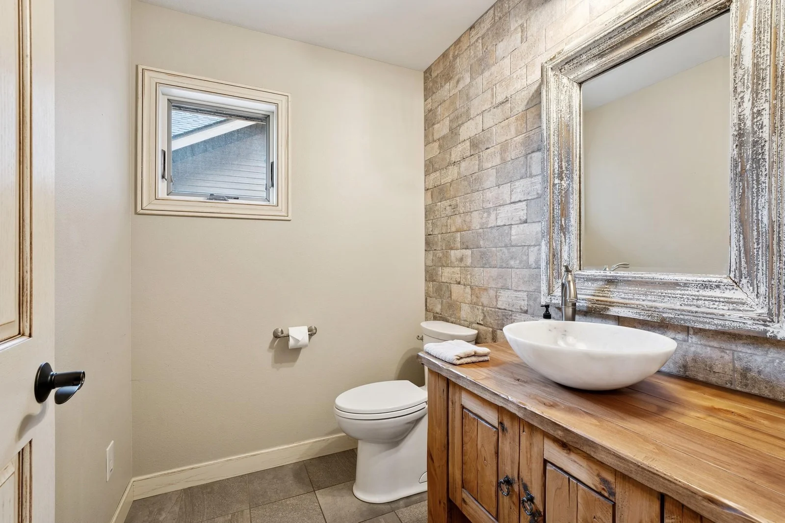 Main floor 1/2 bath with brick accent wall