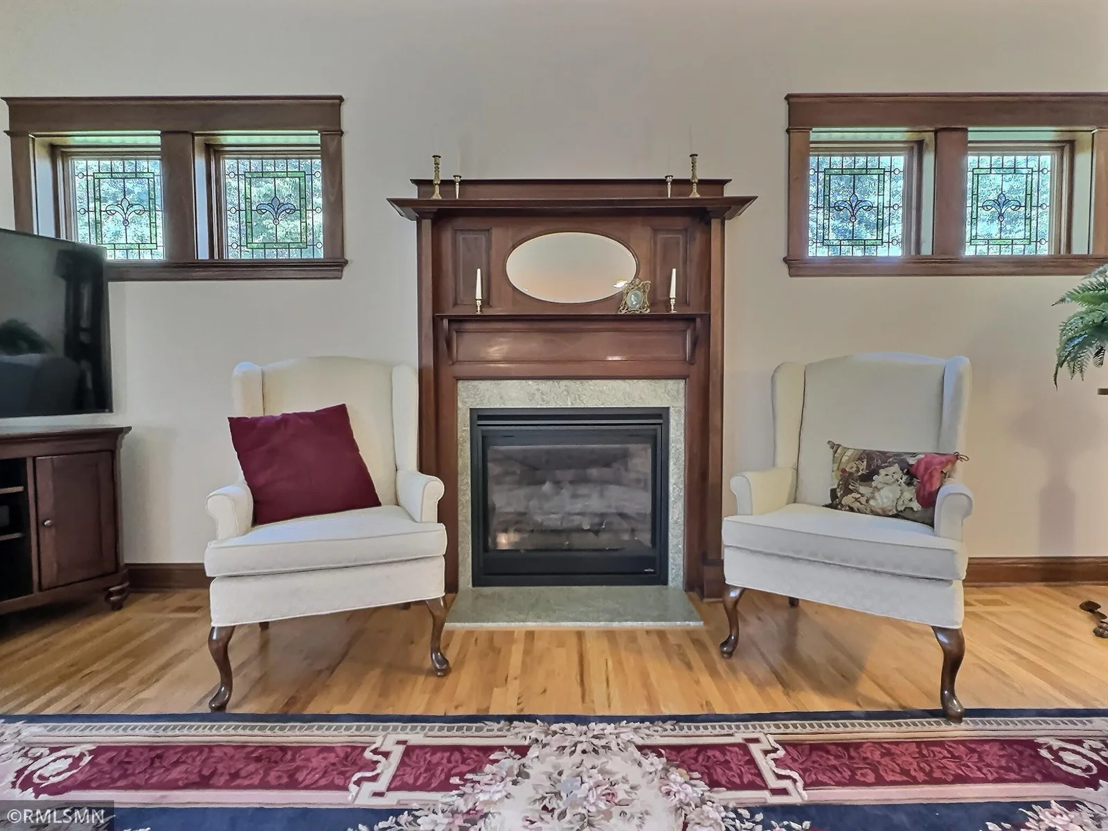 At the heart of the living room, this exquisite antique mantel adds a touch of timeless grandeur framing the cozy yet modern gas fireplace.