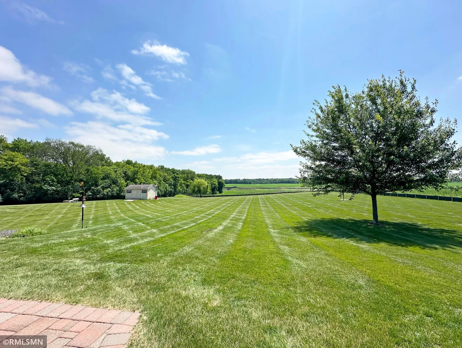 Step into your own private oasis with this expansive backyard, perfectly manicured and stretching toward scenic countryside views.