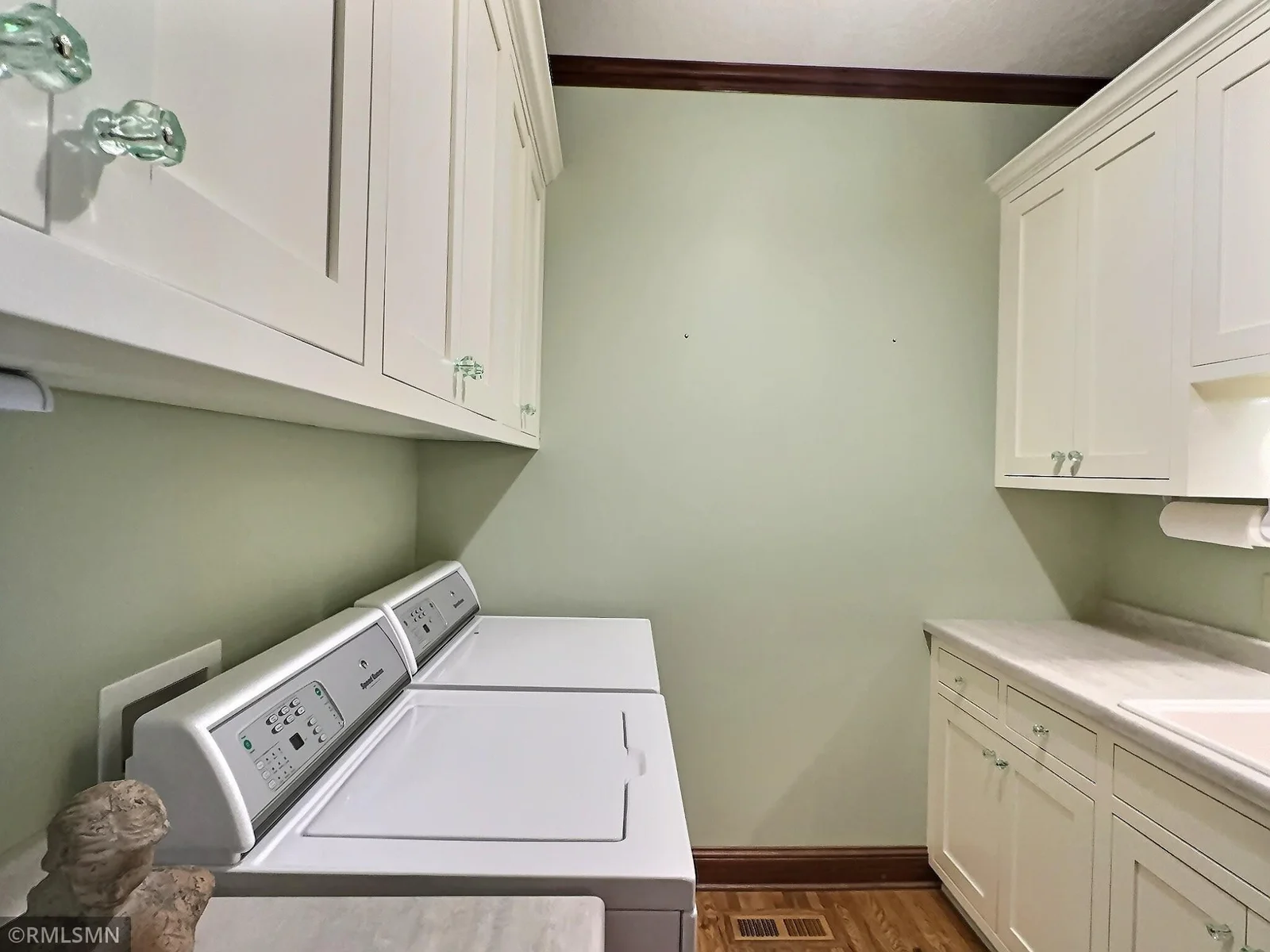 This well-appointed laundry room offers both function and charm with its ample cabinetry, and vintage-inspired glass hardware.