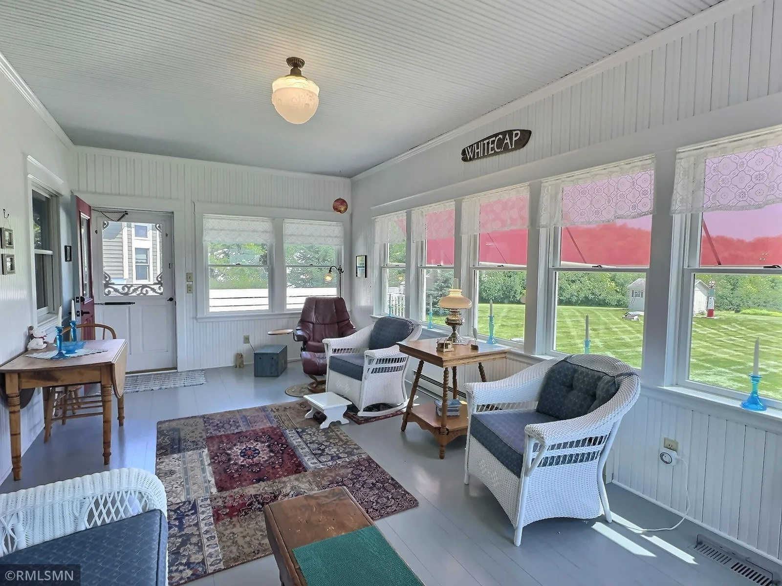 This four-season porch offers a peaceful retreat year-round, wrapped in windows that showcase stunning views of the backyard.