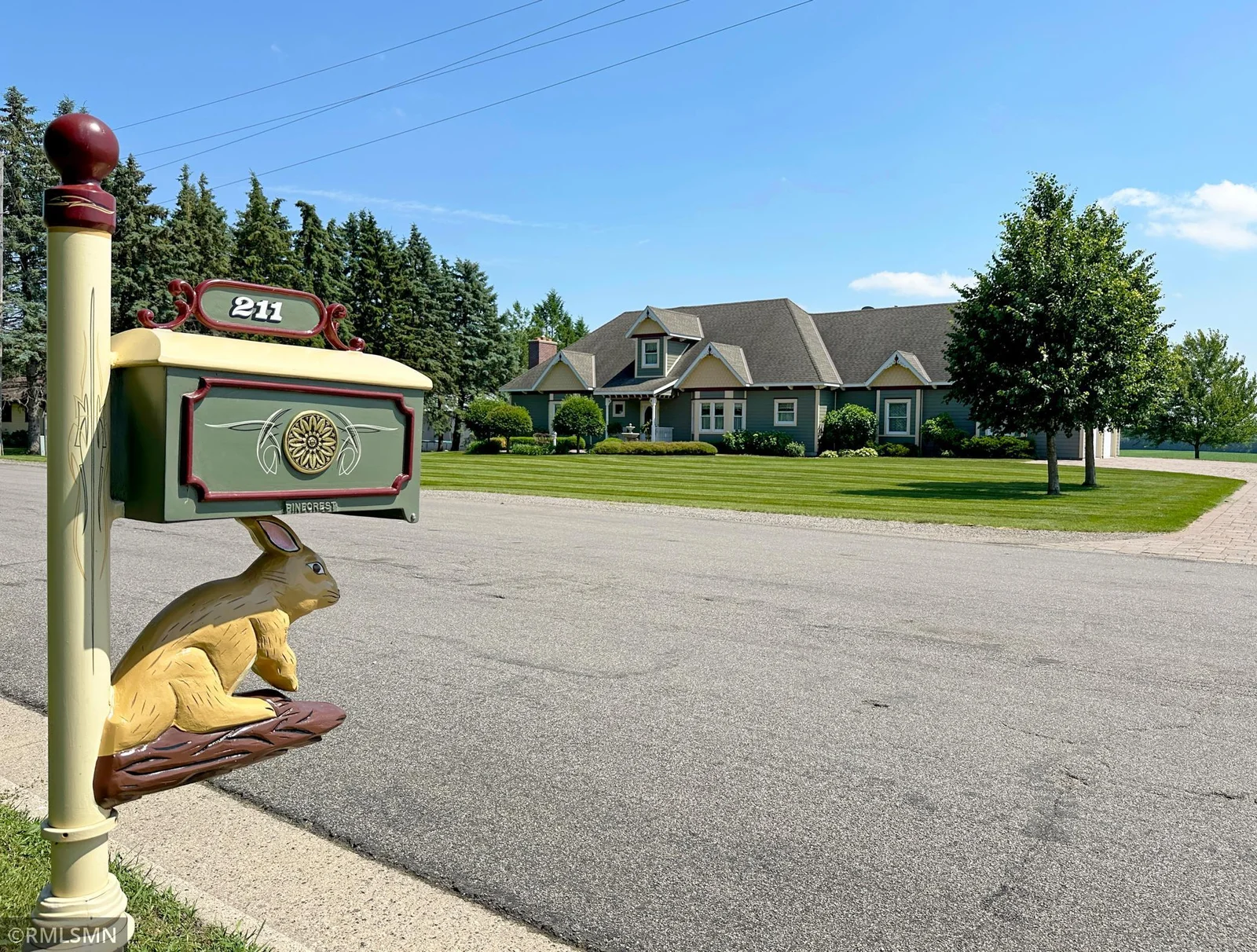 A whimsical and welcoming first impression begins at the curb with this custom mailbox, playfully detailed with a carved rabbit and hand-painted floral accents.