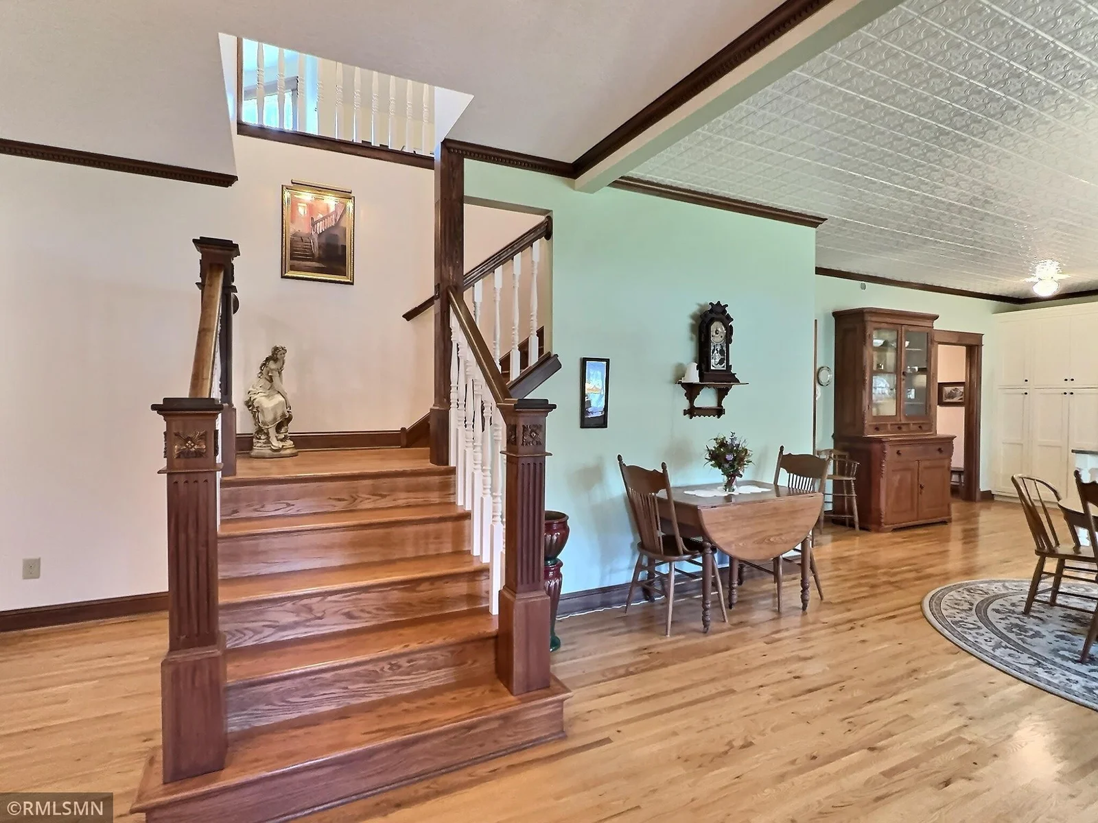 Rich hardwood floors and a striking staircase with carved newel posts and classic white spindles set the tone for the home’s vintage charm.
