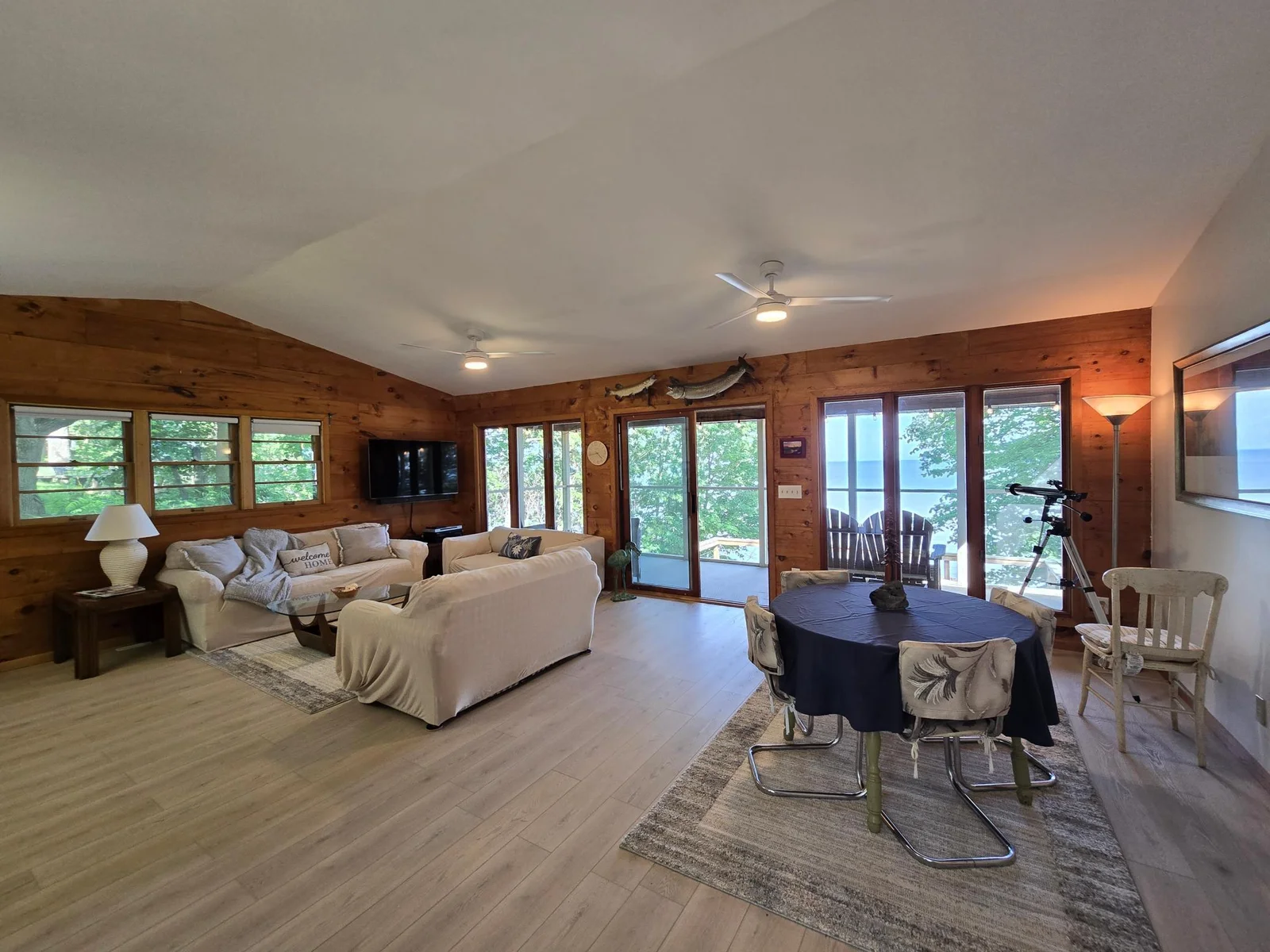 Welcome to the great room, featuring a wall of windows/doors providing for amazing lake views