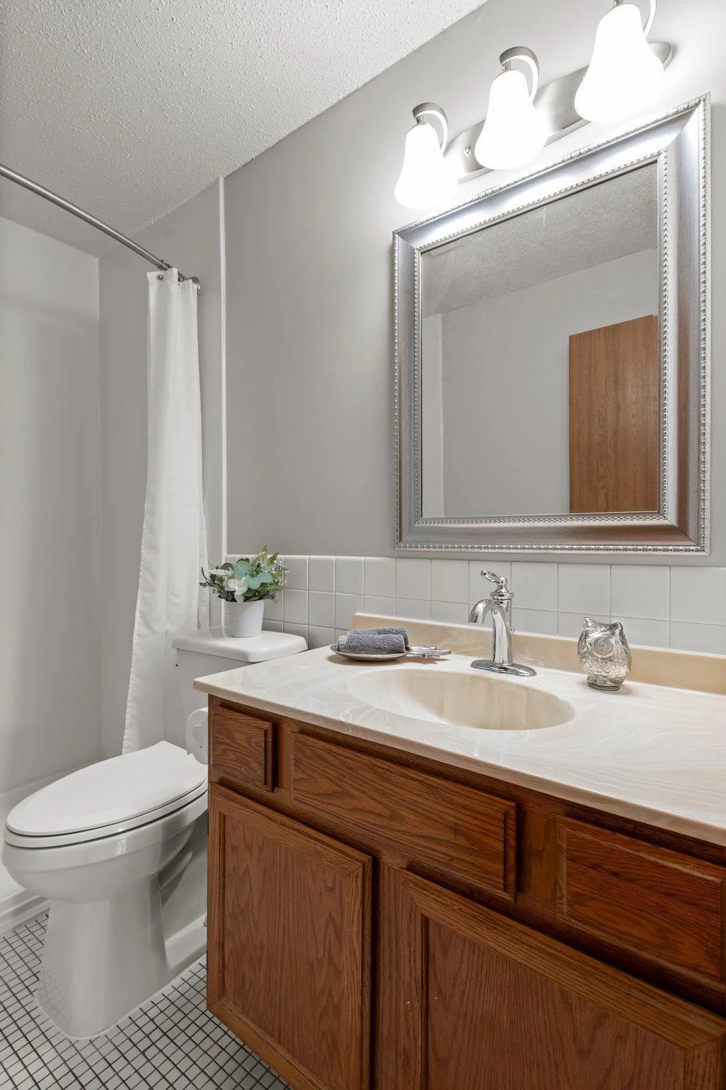New light fixture and vanity mirror update this lovely tiled bath.