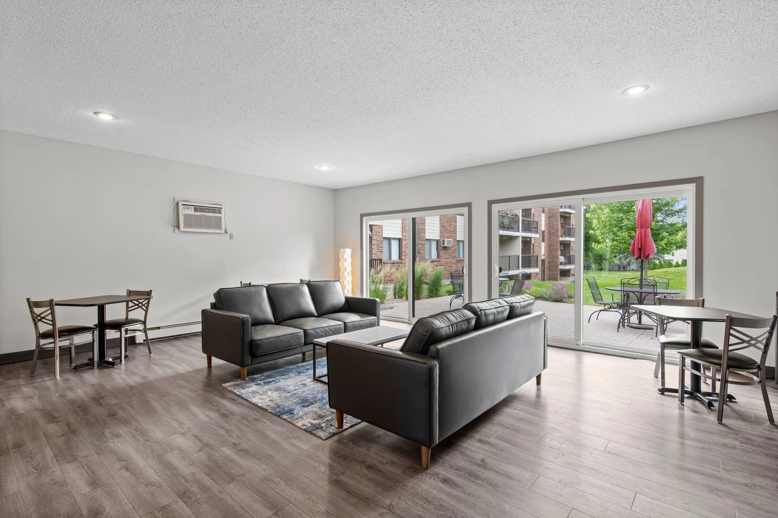 Community room is tastefully furnished, and has large wall of sliding doors leading out to common patio