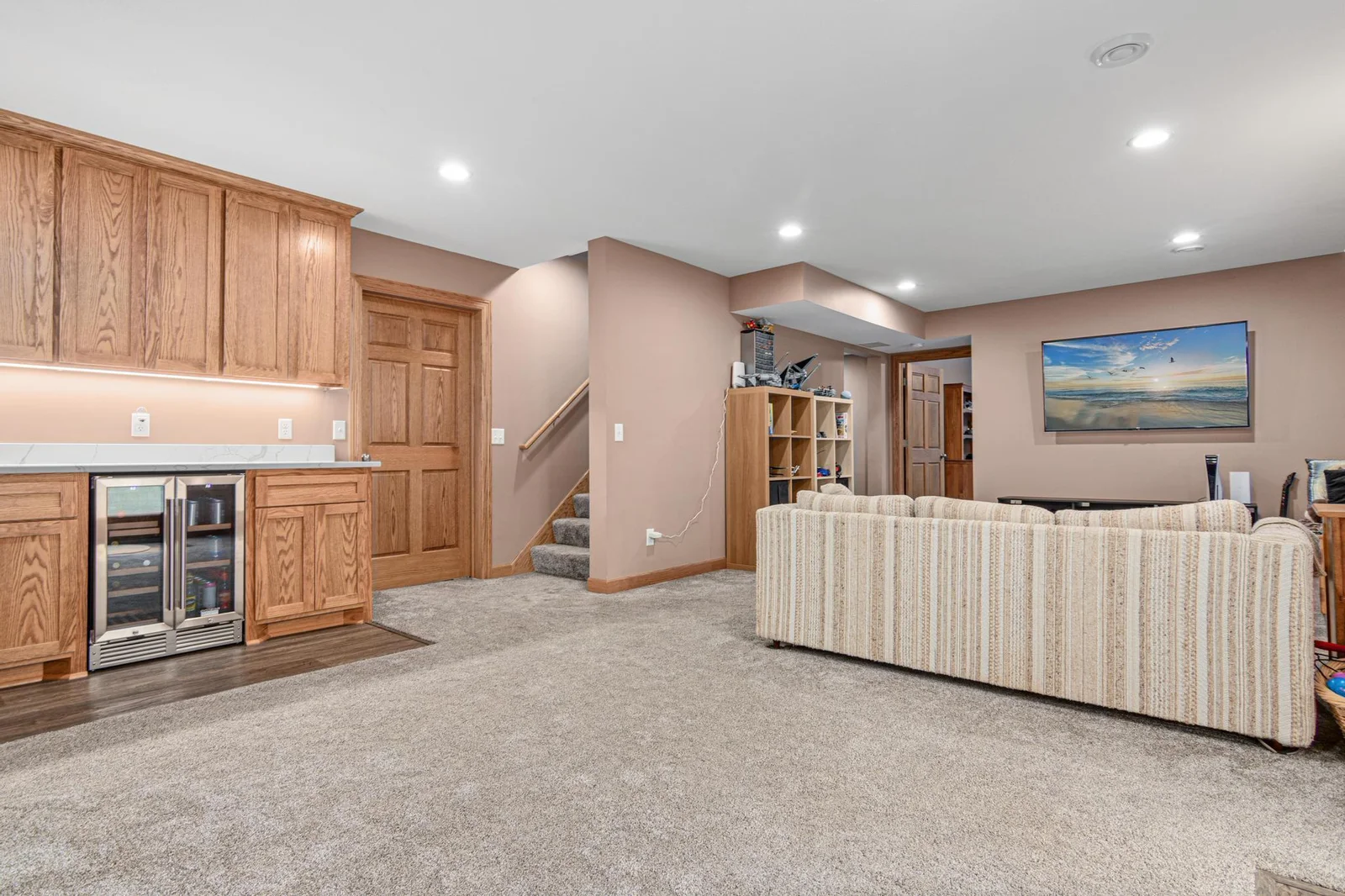 The walk-out lower level was finished with quality in 2021. There is a wet bar, family room, bedroom, and bathroom. Behind that closed door is a huge workroom that runs the length of the house and has two access doors. You won't run out of storage!