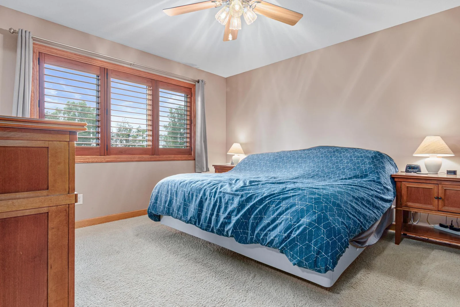 The primary bedoom is on the upper level with two other bedrooms. It has a walk-in closet and private full bathroom. Those window blinds are nice shutter-blinds.