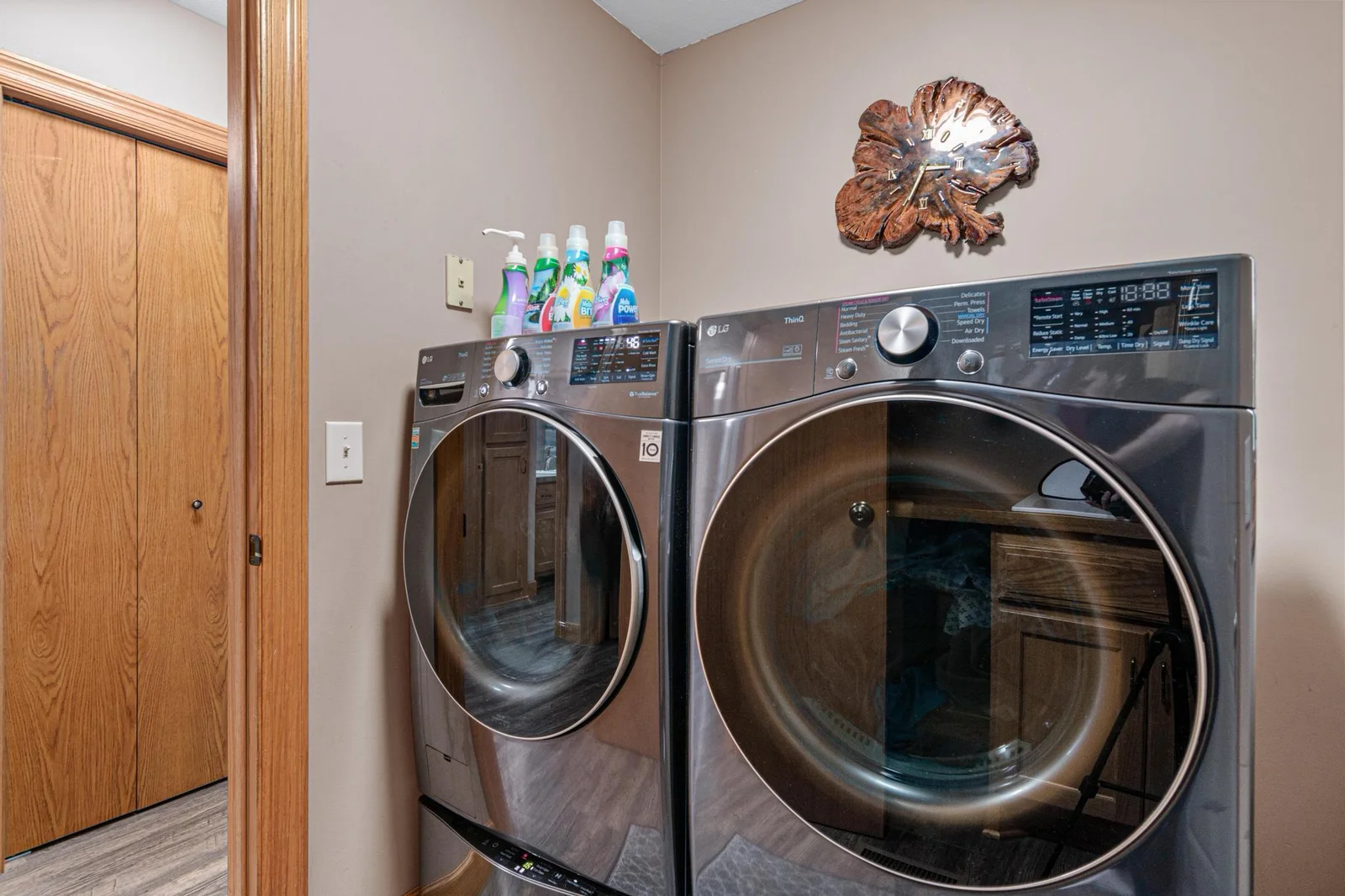 The laundry room is on the main level. The washing machine has a second, smaller washing machine in the drawer area underneath! That is not a storage drawer. That is a second washer! There is a sink, counter, and hanging space on the opposite wall.