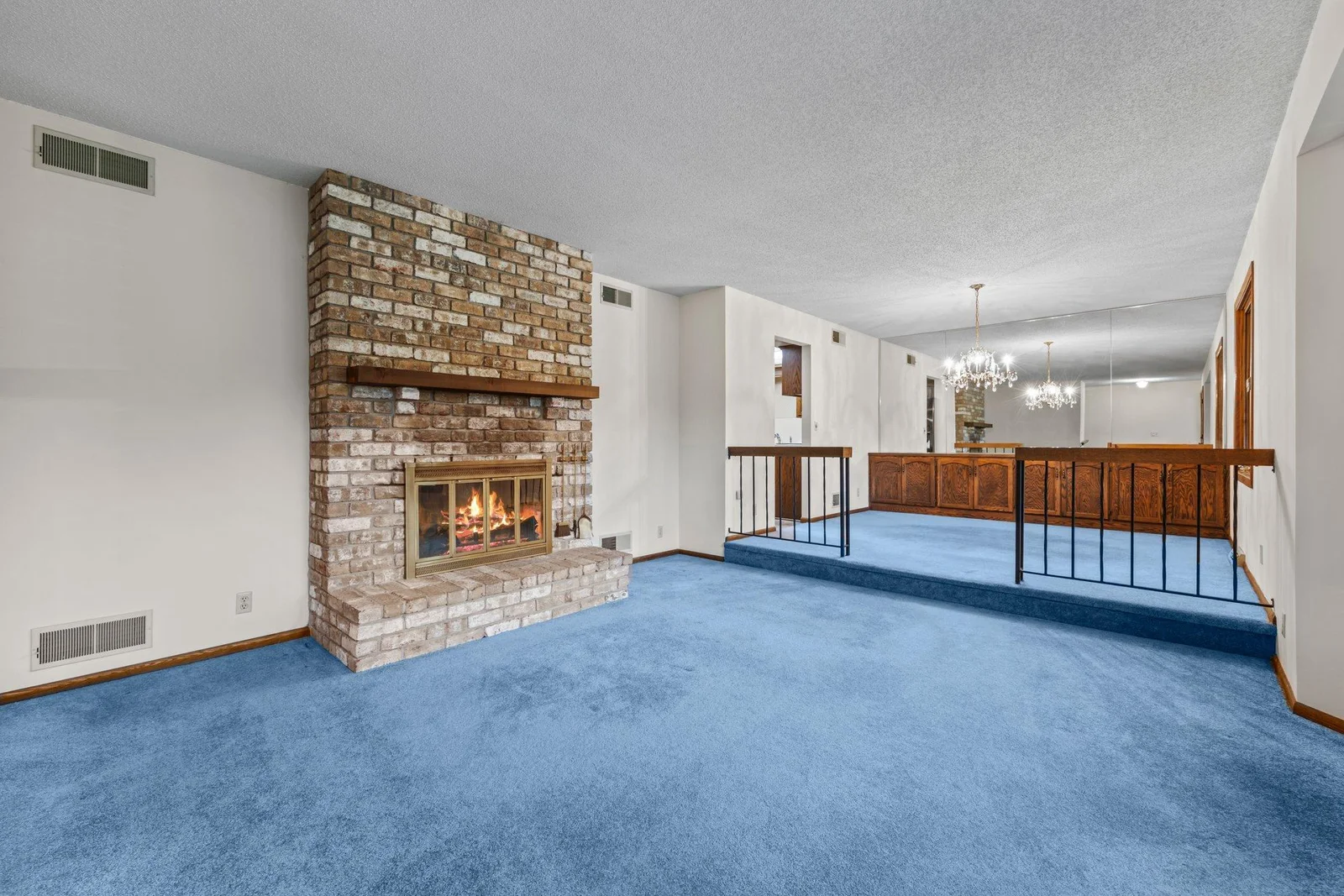 The formal living room is anchored by the brick fireplace. The dining room features a built in buffet and beautiful chandelier.
