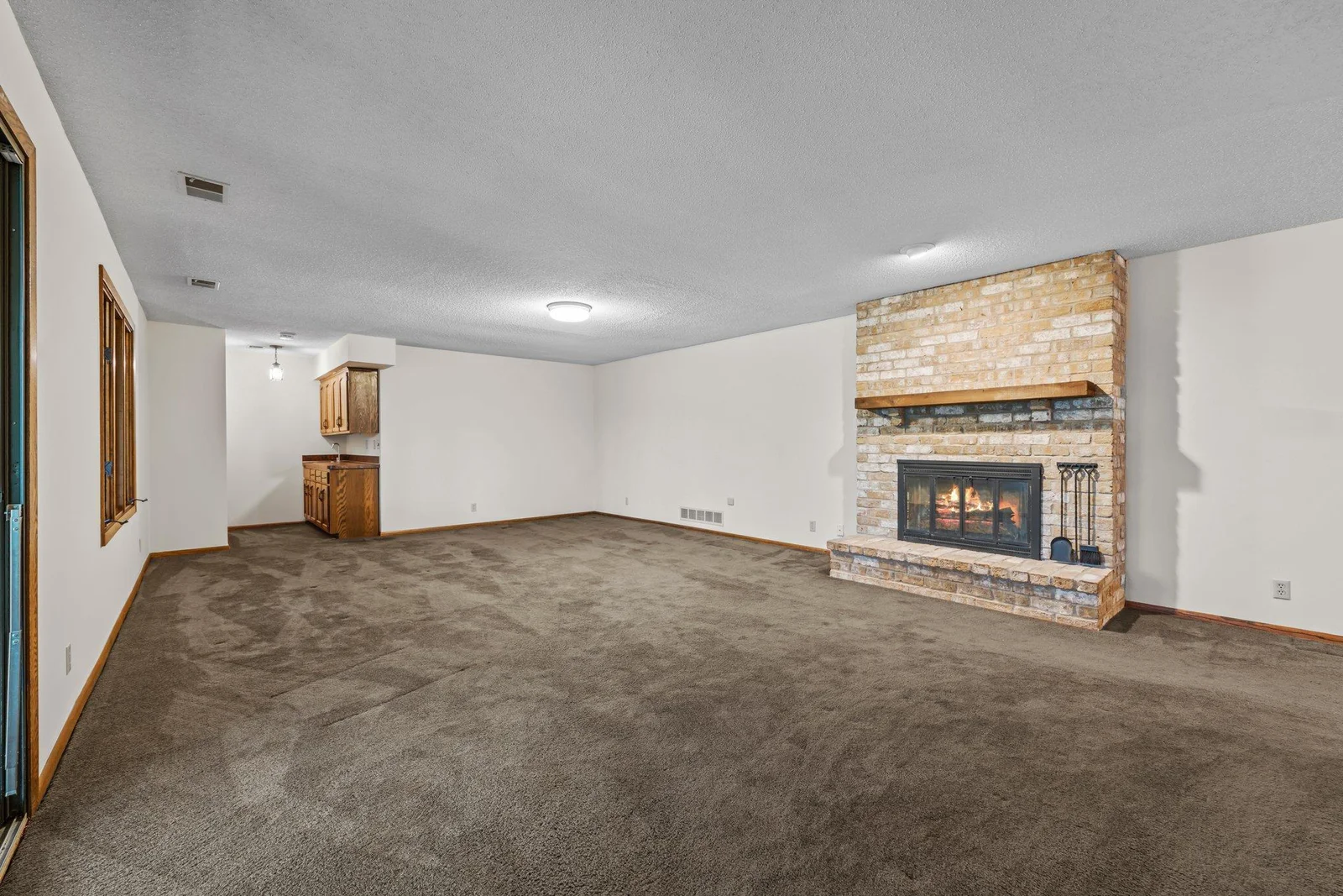 The lower level Recreation Room features a brick fireplace and a wet bar. It is bright with an open concept allowing  many options to furnish it a variety of ways.