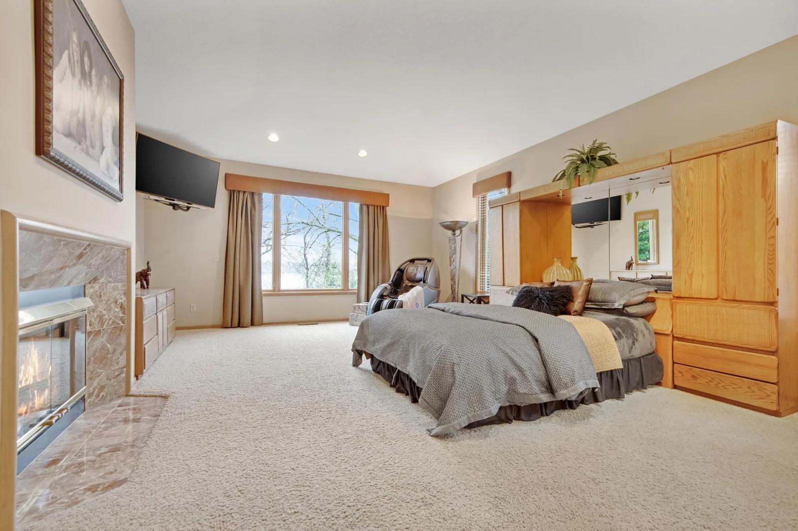 Main floor Primary bedroom with gas fireplace overlooking Lake Virginia