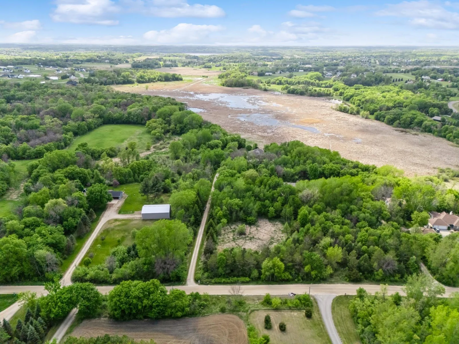 Room to add outbuilding along the right side of driveway! Peaceful setting on 6.5 acres with sweeping views of wildlife filled wetlands and wooded privacy. Accessed by scenic wooded drive that opens to a concrete circular drive.
