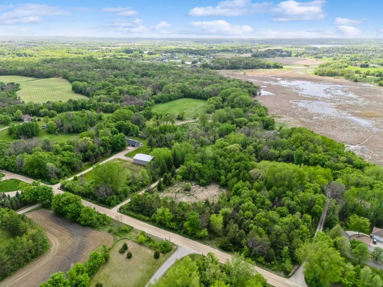 Room to add outbuilding along the right side of driveway! Peaceful setting on 6.5 acres with sweeping views of wildlife filled wetlands and wooded privacy. Accessed by scenic wooded drive that opens to a concrete circular drive.