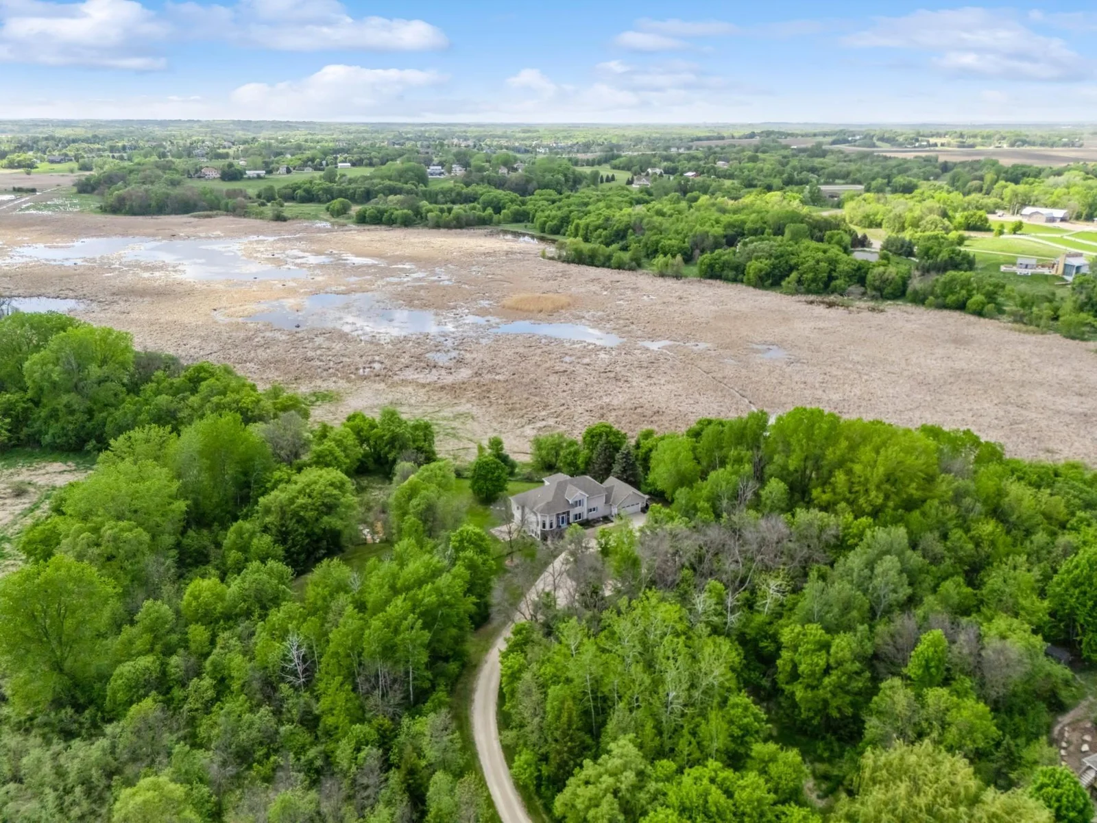 Peaceful setting on 6.5 acres with sweeping views of wildlife filled wetlands and wooded privacy. Accessed by scenic wooded drive that opens to a concrete circular drive.