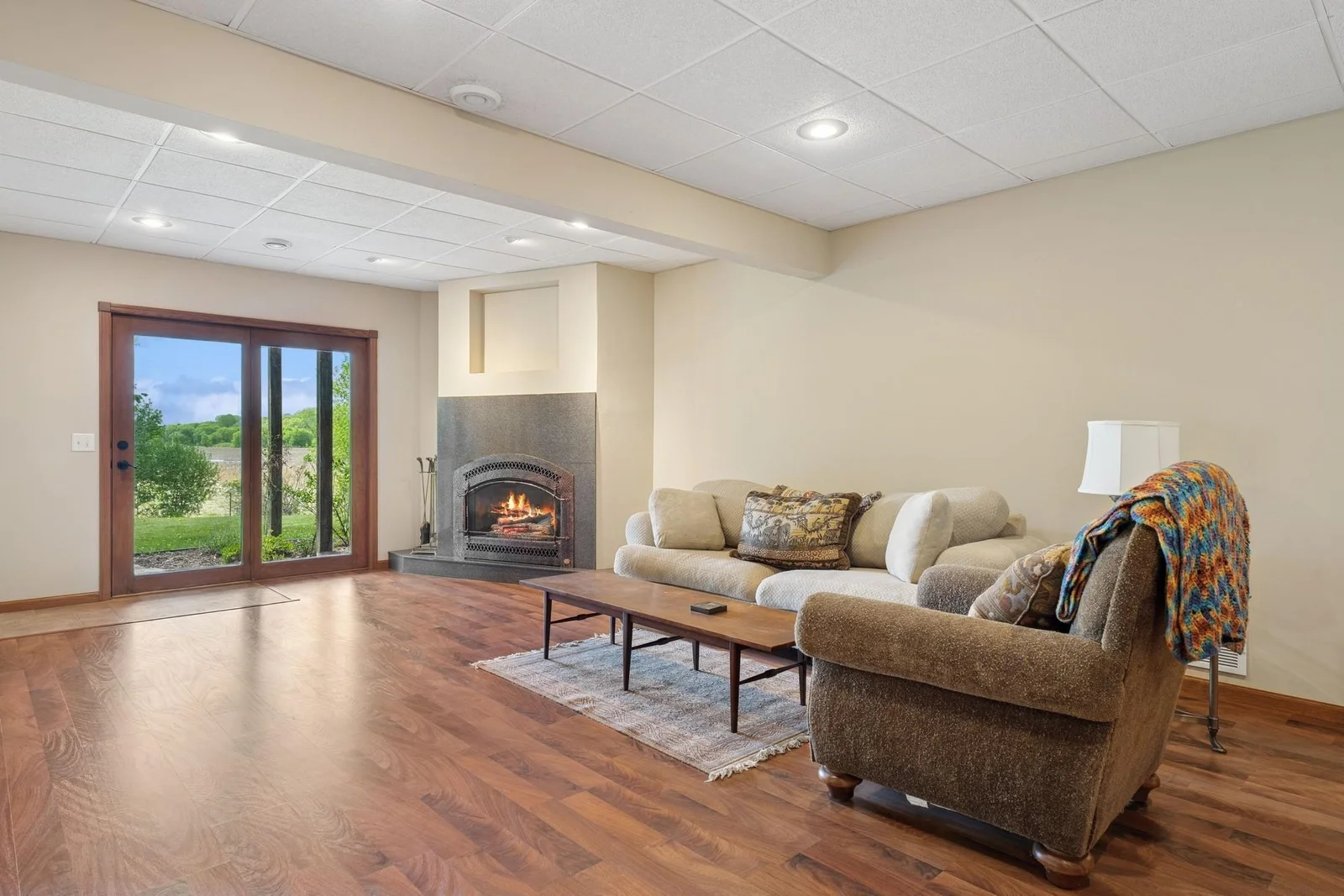 Walkout lower level family room with cozy fireplace and sliders to patio