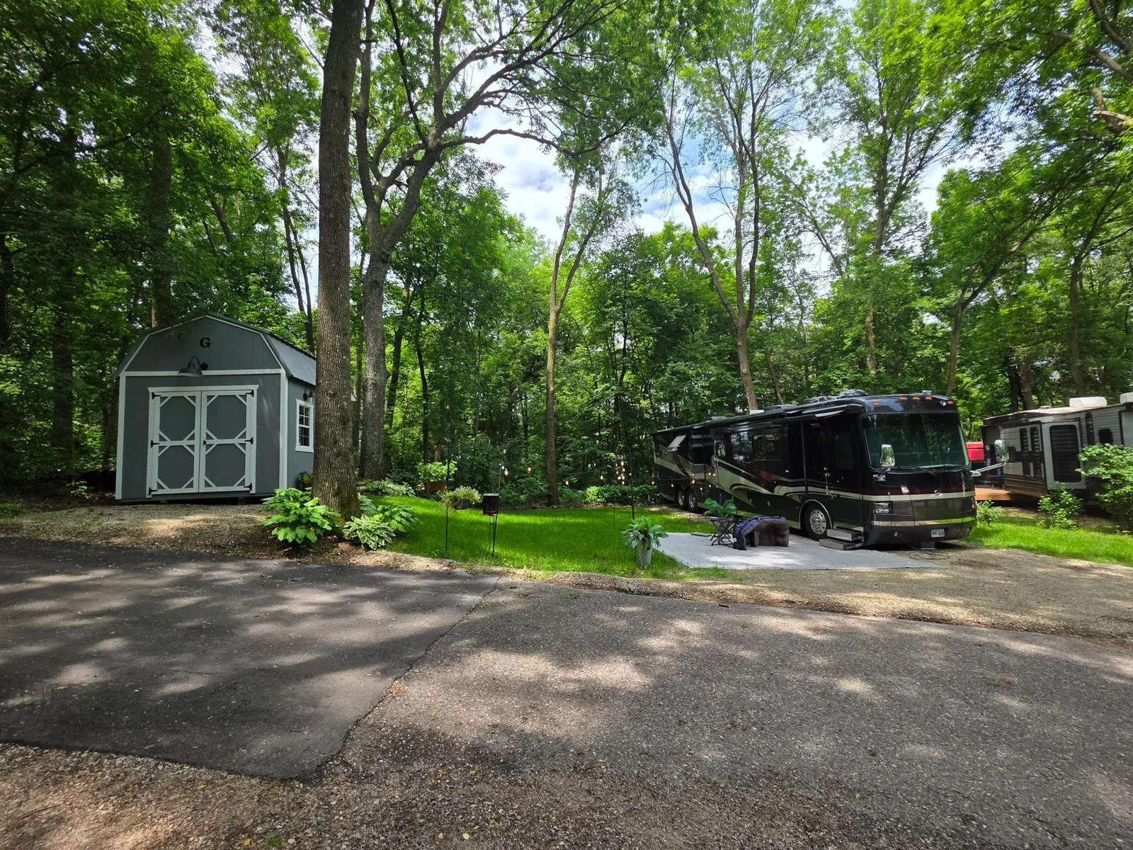 Unit 63 has pretty trees, green grass, a great parking pad for a heavy RV and a nice level pad for a shed.