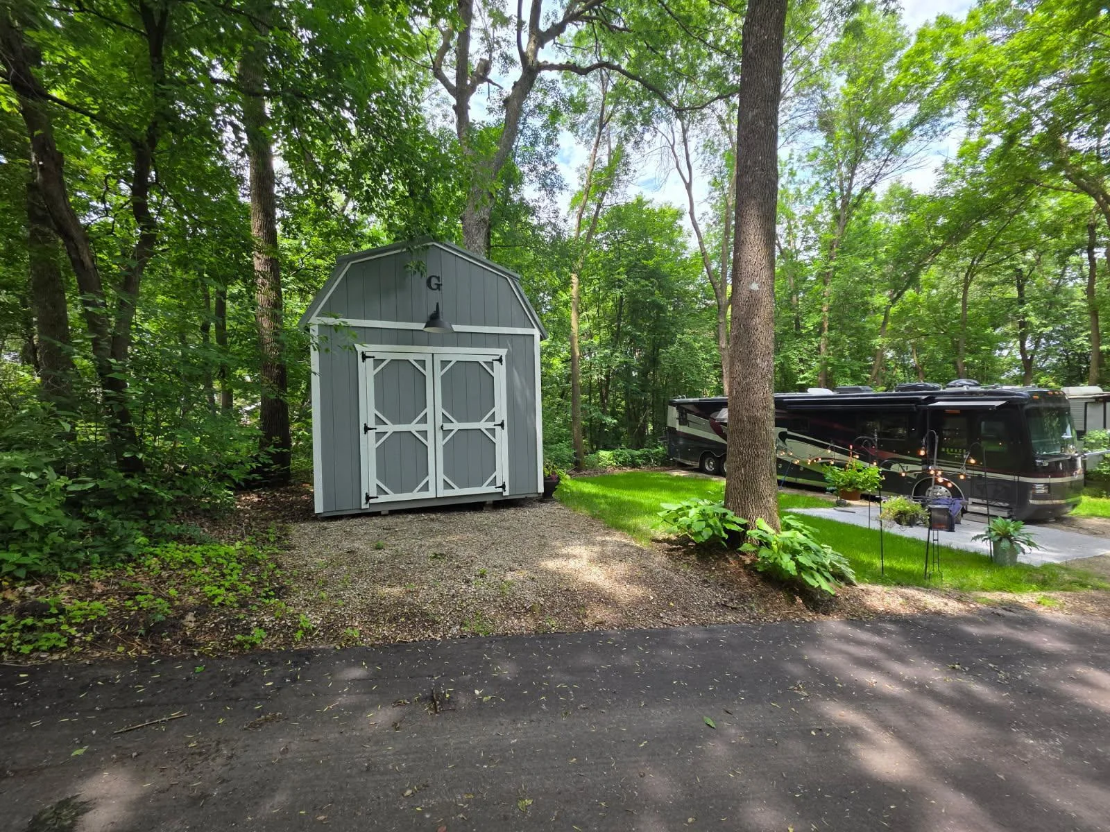 Unit 63 has pretty trees, green grass, a great parking pad for a heavy RV and a nice level pad for a shed.